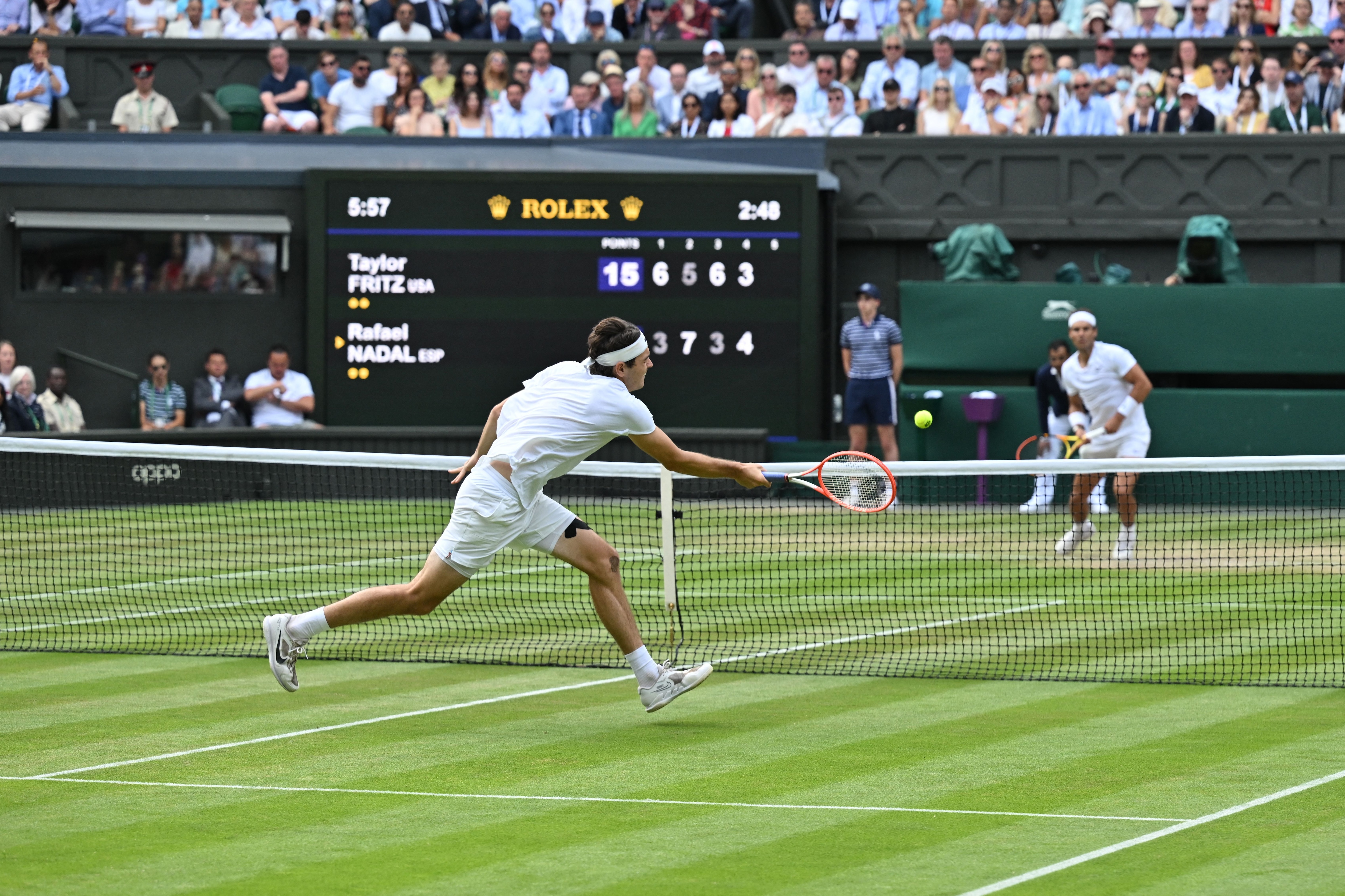 US player Taylor Fritz returns the ball to Spain's Rafael Nadal during their men's singles quarter final tennis match on the tenth day of the 2022 Wimbledon Championships at The All England Tennis Club in Wimbledon, southwest London, on July 6, 2022. - RESTRICTED TO EDITORIAL USE (Photo by Glyn KIRK / AFP) / RESTRICTED TO EDITORIAL USE (Photo by GLYN KIRK/AFP via Getty Images)