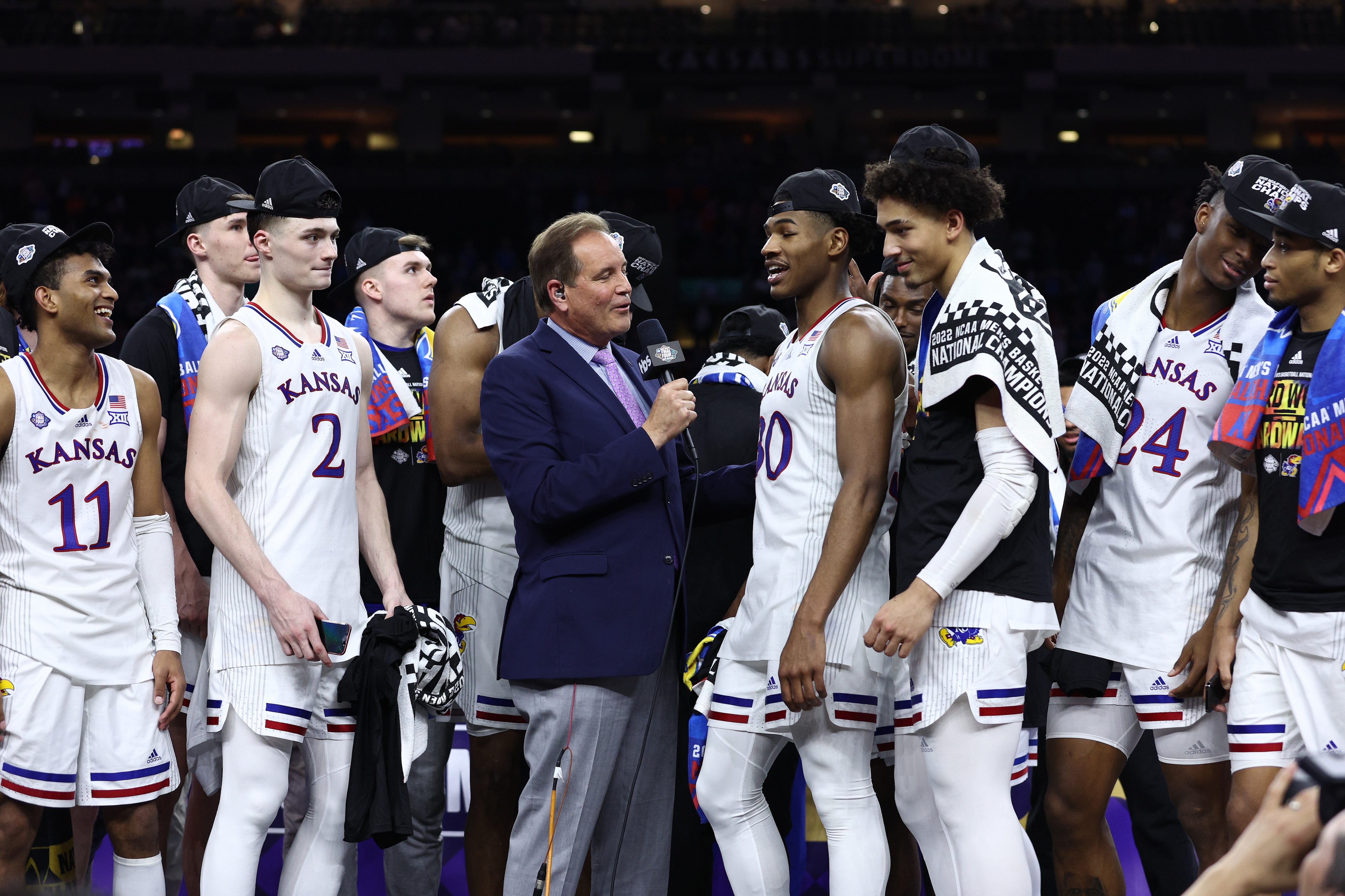 NEW ORLEANS, LOUISIANA - APRIL 04: CBS Sports broadcaster Jim Nantz interviews Ochai Agbaji #30 of the Kansas Jayhawks on the podium after the Kansas Jayhawks defeated the North Carolina Tar Heels 72-69 during the 2022 NCAA Men's Basketball Tournament National Championship at Caesars Superdome on April 04, 2022 in New Orleans, Louisiana. (Photo by Tom Pennington/Getty Images)
