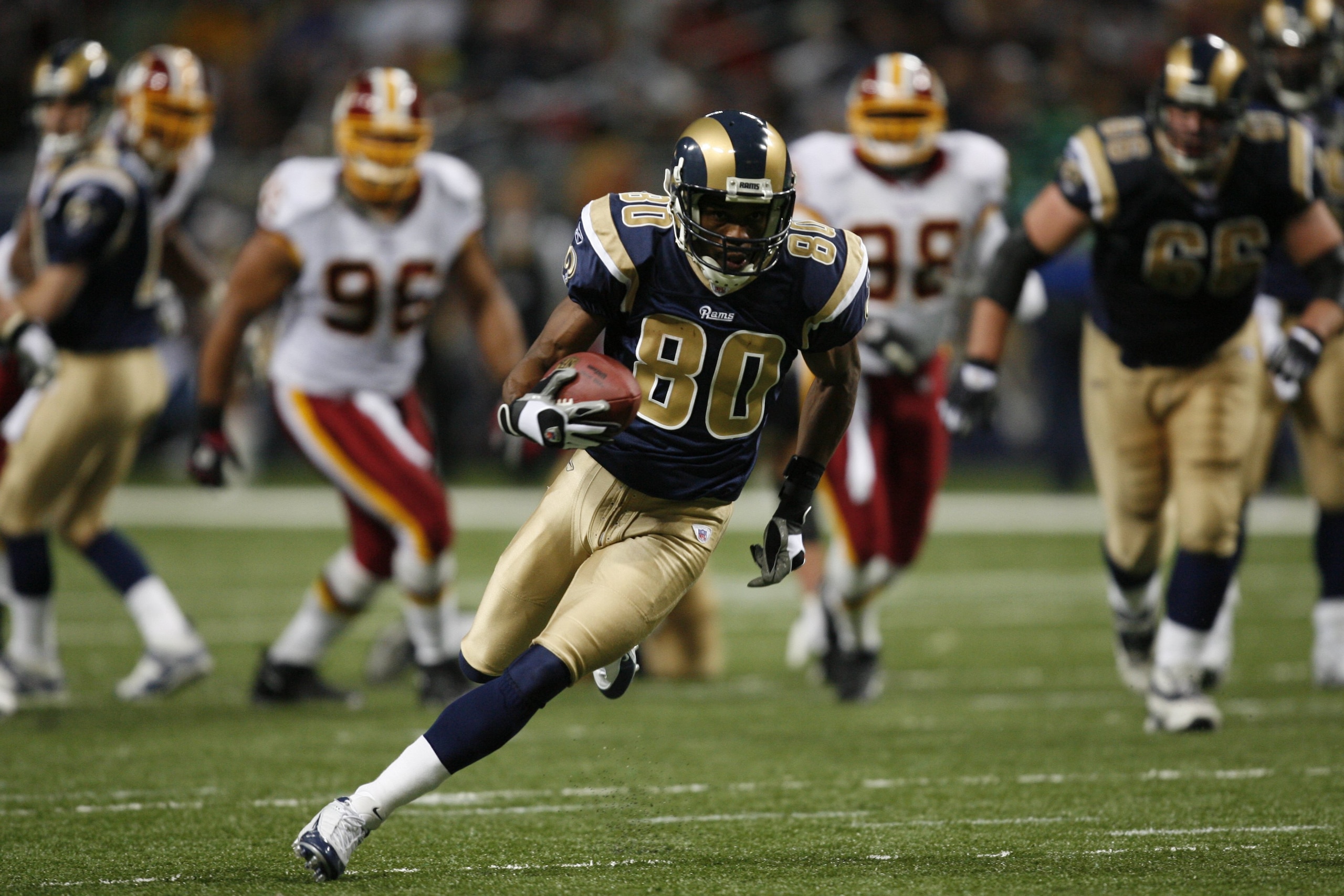 ST. LOUIS, MO - DECEMBER 24: Isaac Bruce #80 of the St. Louis Rams carries the ball against the Washington Redskins at the Edward Jones Dome on December 24, 2006 in St. Louis, Missouri. The Rams won in overtime 37-31. (Photo by Dilip Vishwanat/Getty Images) ST. LOUIS, MO - DECEMBER 24: Isaac Bruce #80 of the St. Louis Rams carries the ball against the Washington Redskins at the Edward Jones Dome on December 24, 2006 in St. Louis, Missouri. The Rams won in overtime 37-31. (Photo by Dilip Vishwanat/Getty Images)