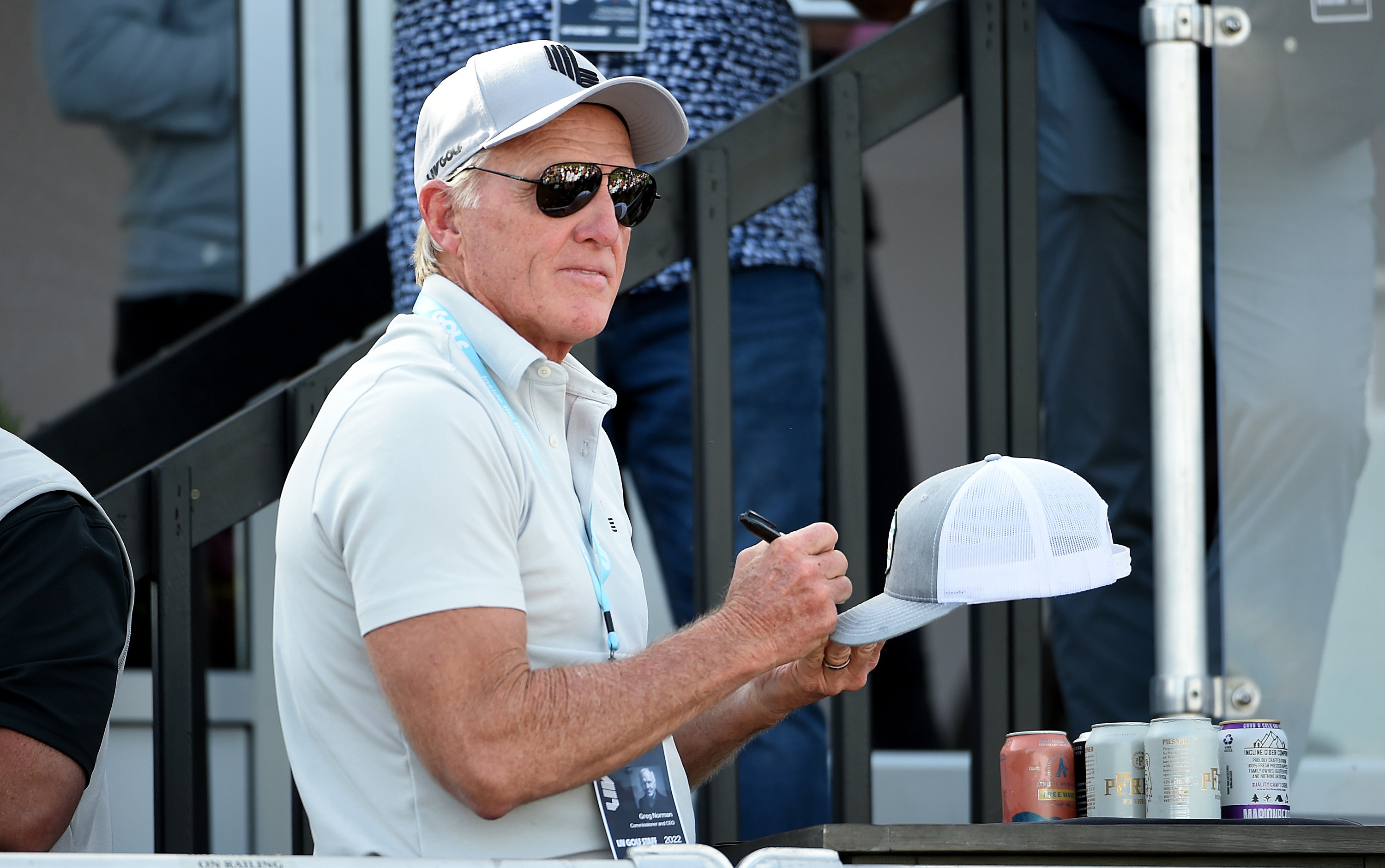 NORTH PLAINS, OREGON - JULY 02: LIV Golf commissioner Greg Norman signs hats from the deck of a pavilion on the 18th green during the final round of the LIV Golf Invitational - Portland at Pumpkin Ridge Golf Club on July 02, 2022 in North Plains, Oregon. (Photo by Steve Dykes/Getty Images)