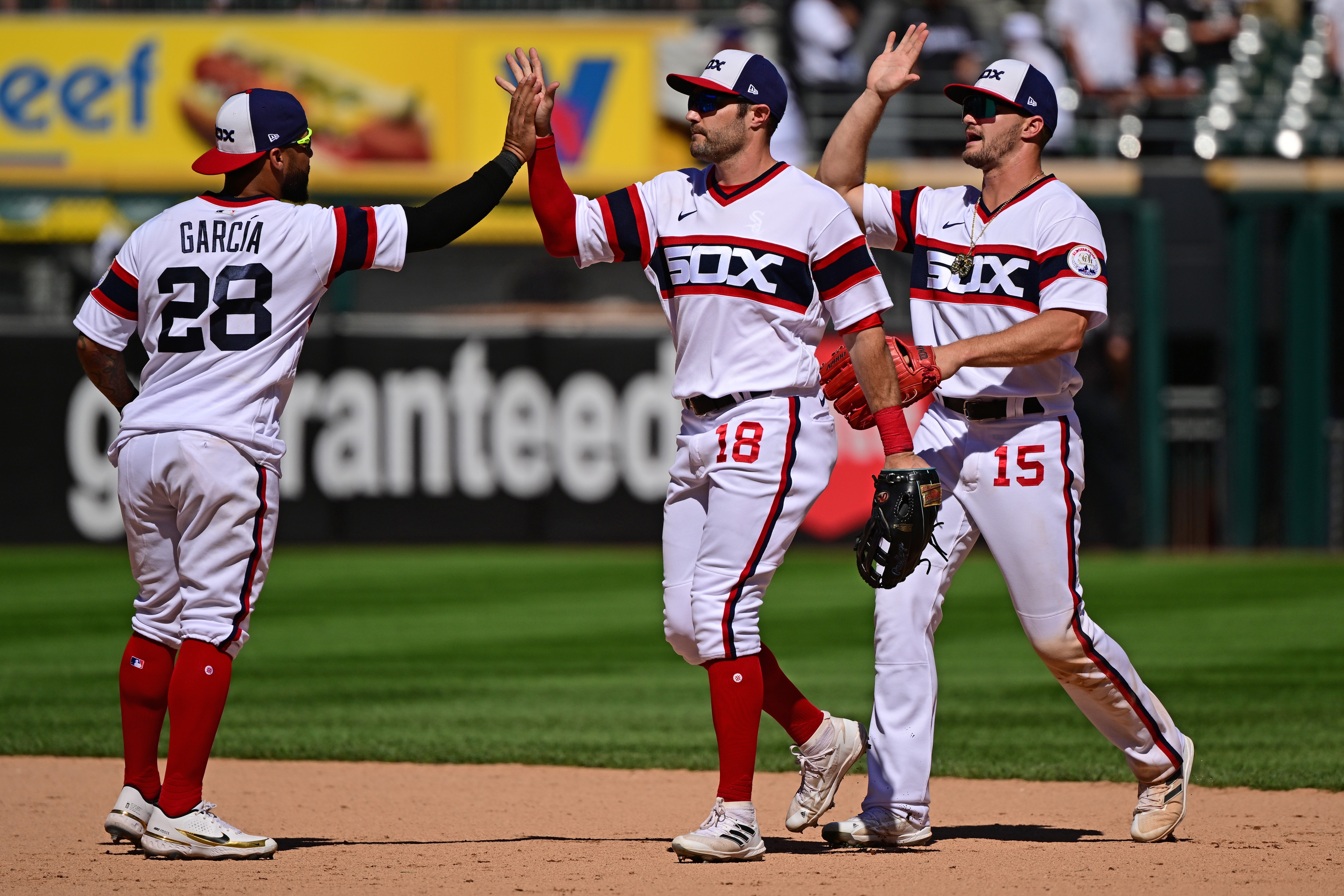 CHICAGO, ILLINOIS - JULY 10: AJ Pollock #18, Leury Garcia #28, and Adam Engel #15 of the Chicago White Sox celebrate the 4-2 win against the Detroit Tigers at Guaranteed Rate Field on July 10, 2022 in Chicago, Illinois. (Photo by Quinn Harris/Getty Images)