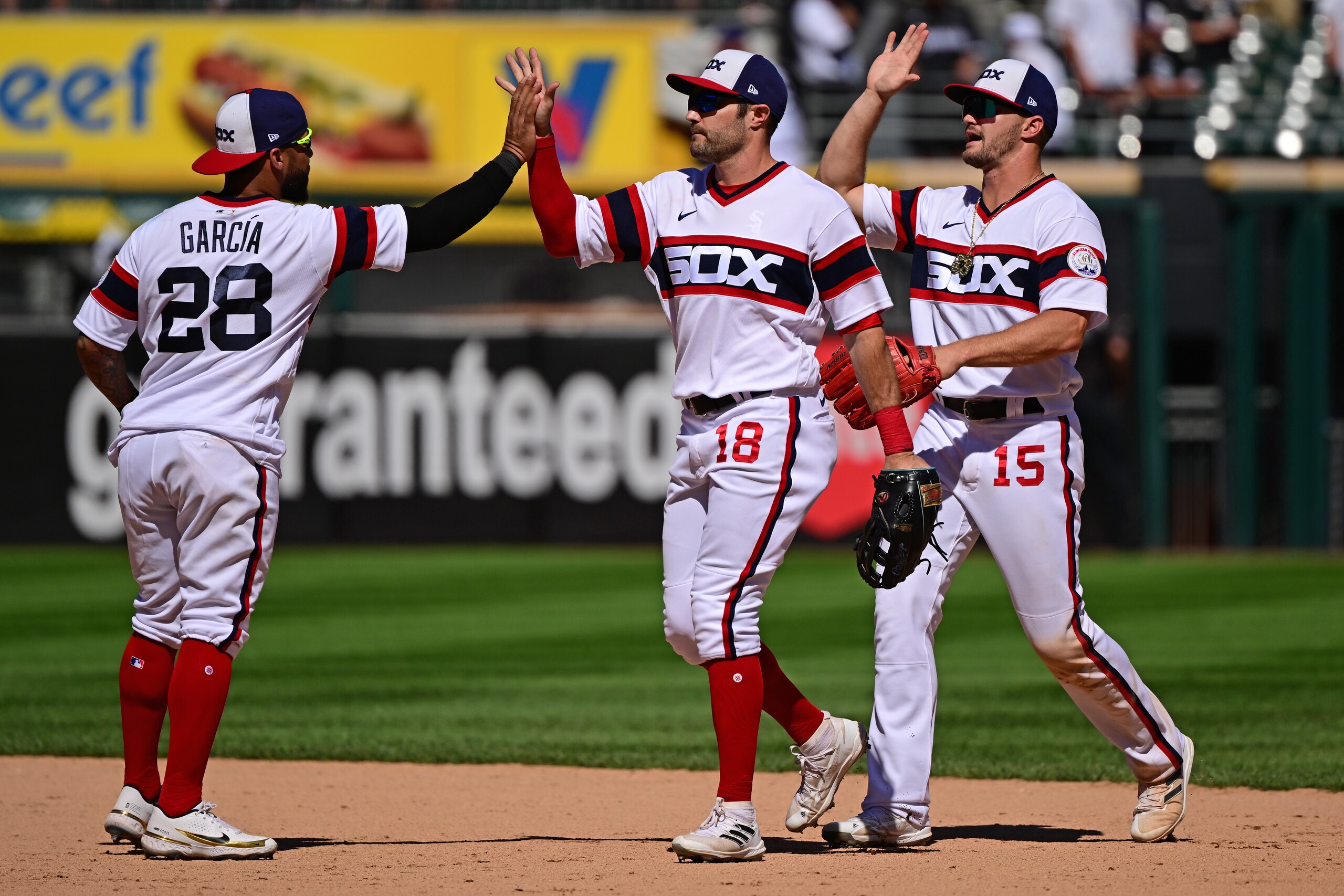 CHICAGO, ILLINOIS - JULY 10: AJ Pollock #18, Leury Garcia #28, and Adam Engel #15 of the Chicago White Sox celebrate the 4-2 win against the Detroit Tigers at Guaranteed Rate Field on July 10, 2022 in Chicago, Illinois. (Photo by Quinn Harris/Getty Images)