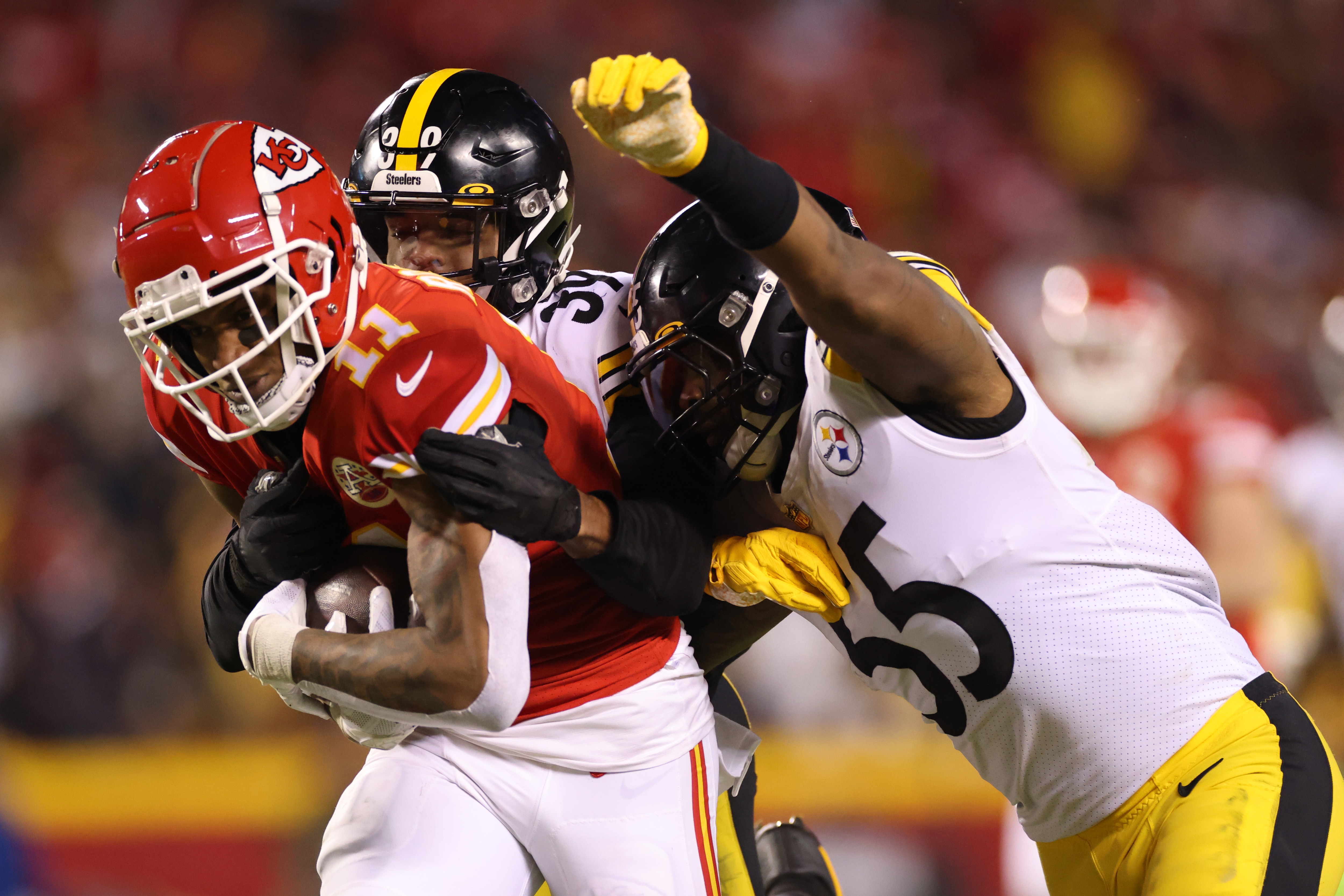 KANSAS CITY, MISSOURI - JANUARY 16: Demarcus Robinson #11 of the Kansas City Chiefs runs with the ball as Devin Bush #55 and Minkah Fitzpatrick #39 of the Pittsburgh Steelers try to defend in the third quarter in the NFC Wild Card Playoff game at Arrowhead Stadium on January 16, 2022 in Kansas City, Missouri. (Photo by David Eulitt/Getty Images)