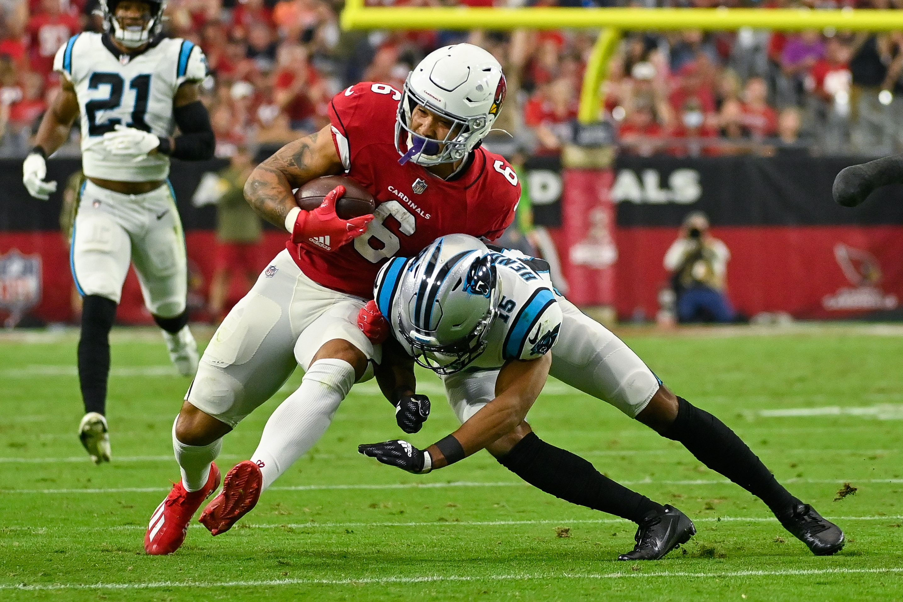 GLENDALE, ARIZONA - NOVEMBER 14: James Conner #6 of the Arizona Cardinals is brought down by CJ Henderson #14 of the Carolina Panthers in the third quarter at State Farm Stadium on November 14, 2021 in Glendale, Arizona. The Panthers defeated the Cardinals 34-10. (Photo by Kelsey Grant/Getty Images)