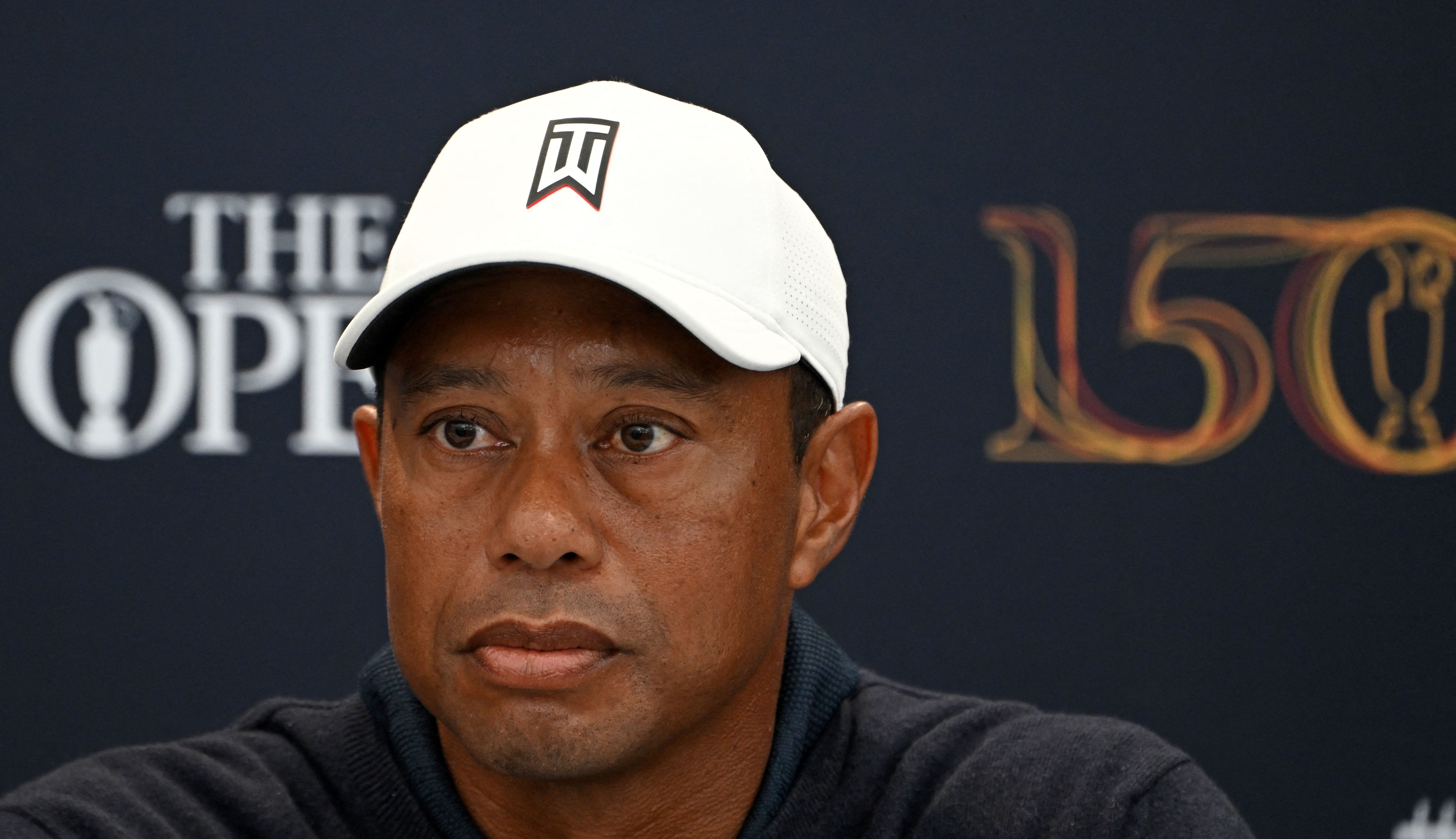 US golfer Tiger Woods attends a press conference held ahead of The 150th British Open Golf Championship on The Old Course at St Andrews in Scotland on July 12, 2022. - RESTRICTED TO EDITORIAL USE (Photo by Paul ELLIS / AFP) / RESTRICTED TO EDITORIAL USE (Photo by PAUL ELLIS/AFP via Getty Images)