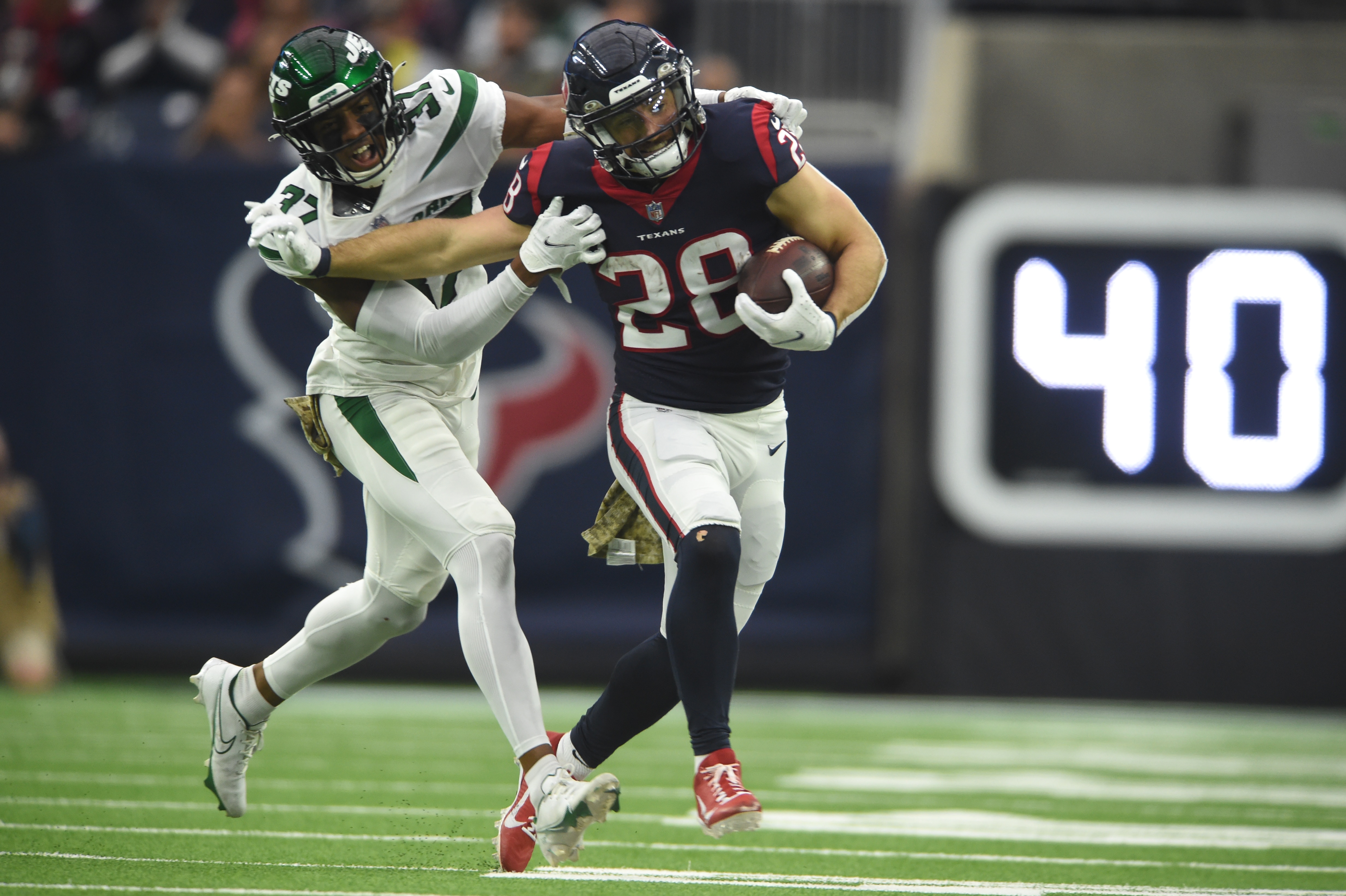 HOUSTON, TX - NOVEMBER 28: Houston Texans RB Rex Burkhead (28) runs for yardage while being chased by New York Jets DB Bryce Hall (37) during game featuring the Houston Texans and the New York Jets on November 28, 2021 at NRG Stadium in Houston, TX. (Photo by John Rivera/Icon Sportswire via Getty Images)