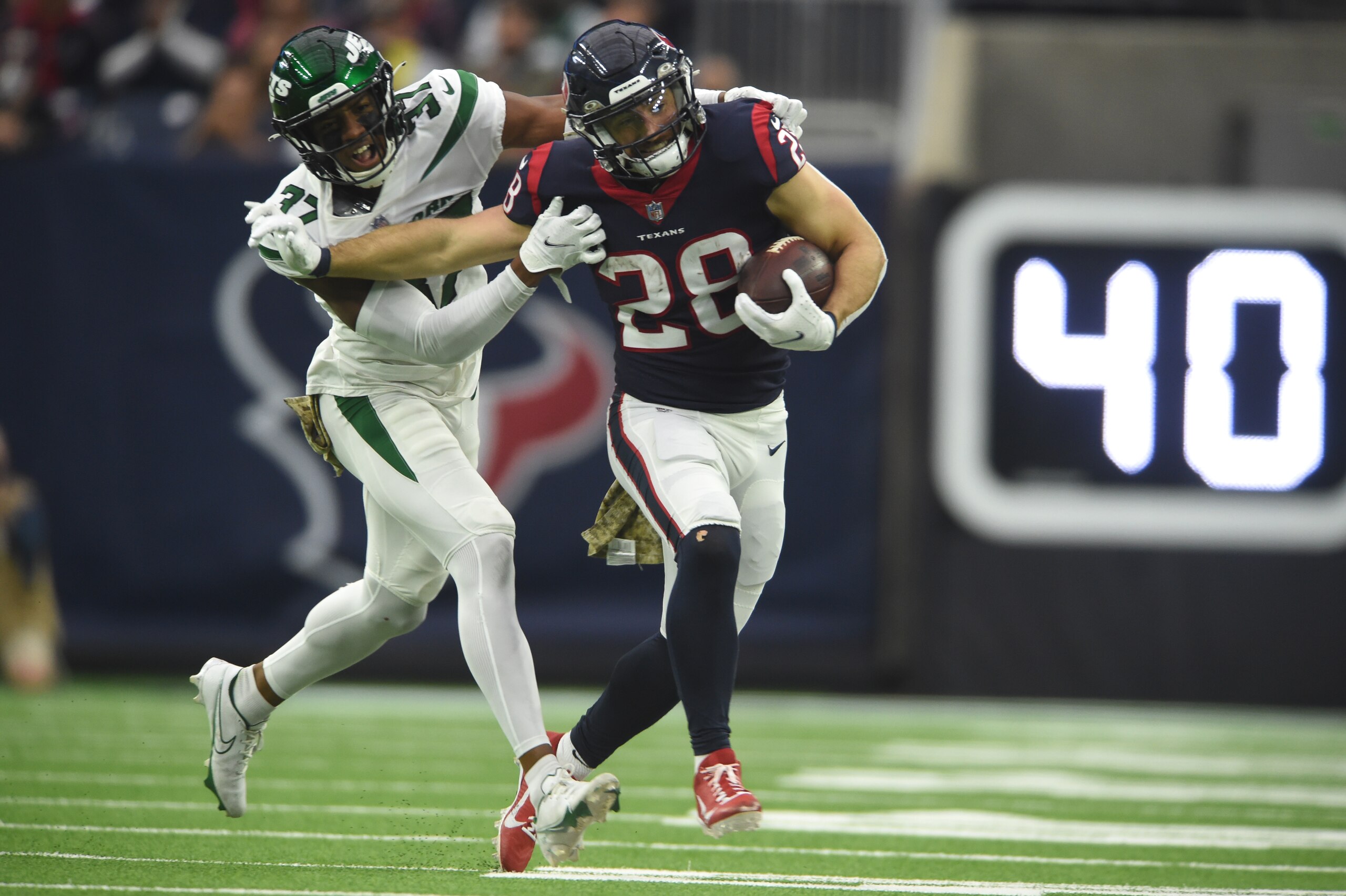 HOUSTON, TX - NOVEMBER 28: Houston Texans RB Rex Burkhead (28) runs for yardage while being chased by New York Jets DB Bryce Hall (37) during game featuring the Houston Texans and the New York Jets on November 28, 2021 at NRG Stadium in Houston, TX. (Photo by John Rivera/Icon Sportswire via Getty Images)