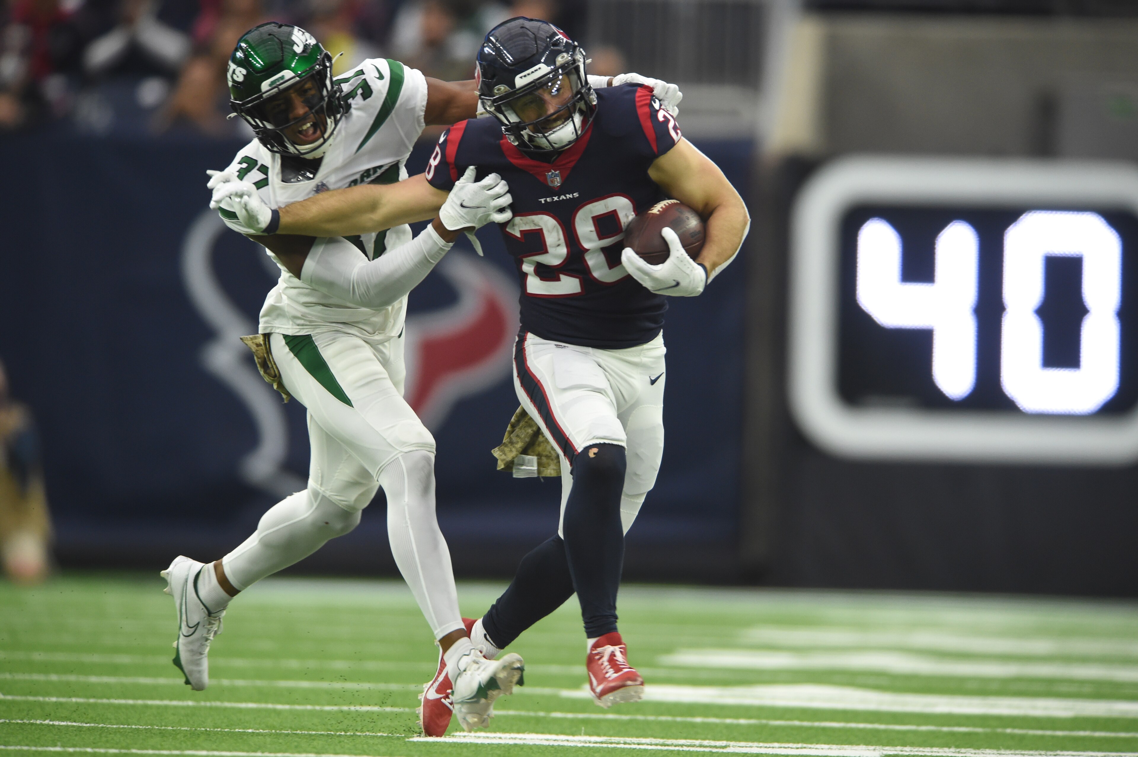 HOUSTON, TX - NOVEMBER 28: Houston Texans RB Rex Burkhead (28) runs for yardage while being chased by New York Jets DB Bryce Hall (37) during game featuring the Houston Texans and the New York Jets on November 28, 2021 at NRG Stadium in Houston, TX. (Photo by John Rivera/Icon Sportswire via Getty Images)