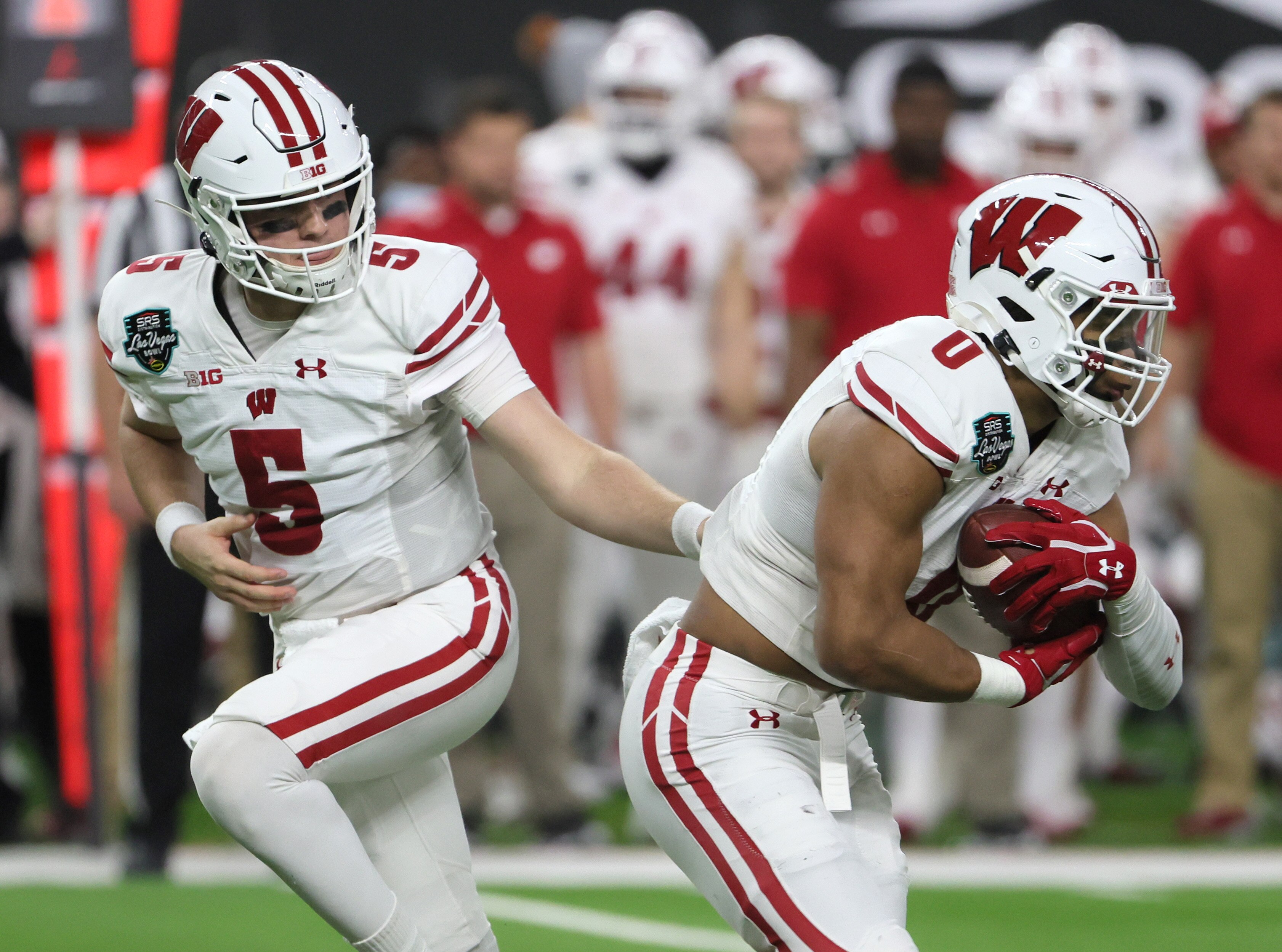 LAS VEGAS, NEVADA - DECEMBER 30:  Quarterback Graham Mertz #5 of the Wisconsin Badgers hands the ball off to running back Braelon Allen #0 against the Arizona State Sun Devils during the SRS Distribution Las Vegas Bowl at Allegiant Stadium on December 30, 2021 in Las Vegas, Nevada. The Badgers defeated the Sun Devils 20-13.  (Photo by Ethan Miller/Getty Images)