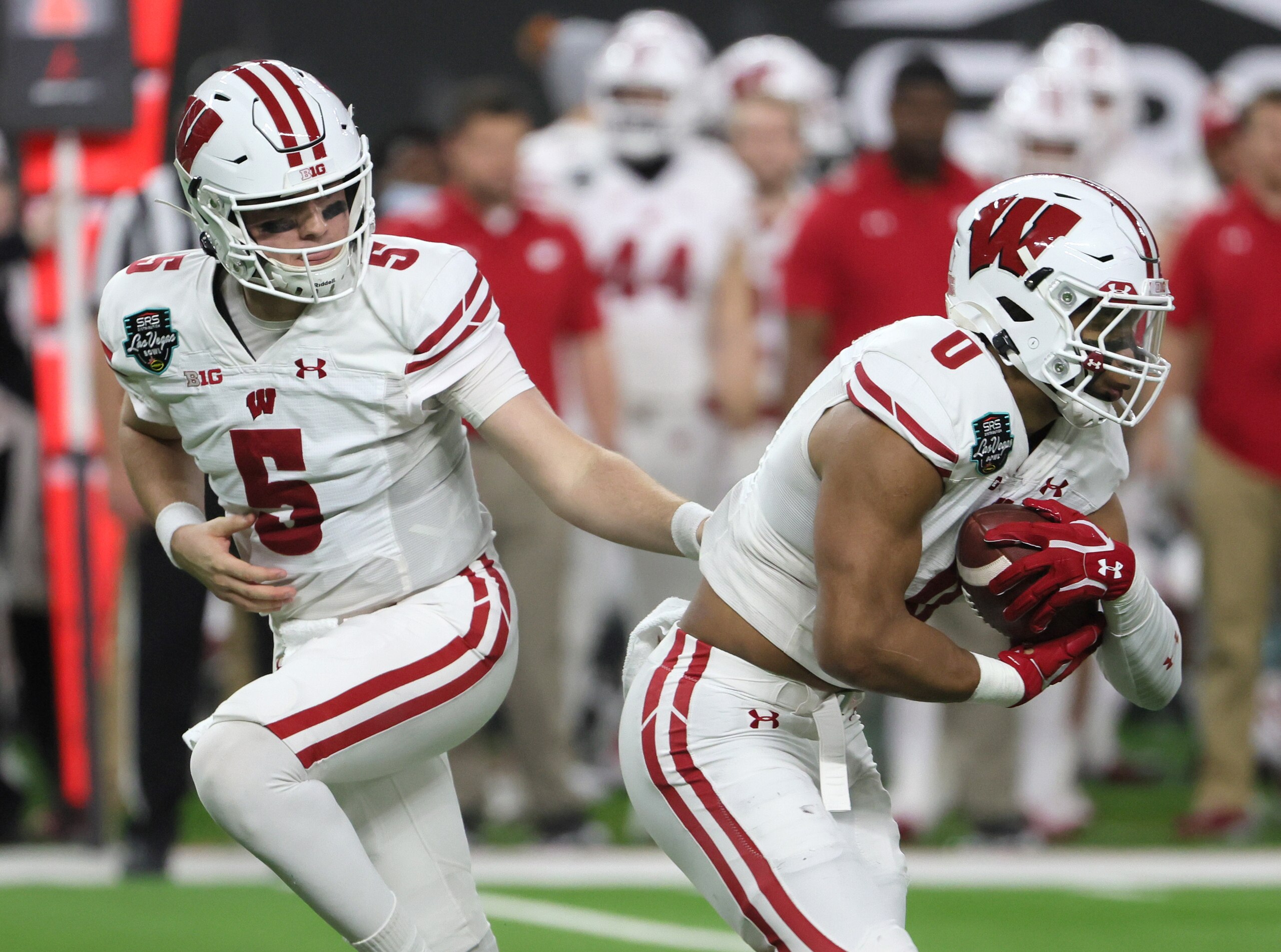 LAS VEGAS, NEVADA - DECEMBER 30:  Quarterback Graham Mertz #5 of the Wisconsin Badgers hands the ball off to running back Braelon Allen #0 against the Arizona State Sun Devils during the SRS Distribution Las Vegas Bowl at Allegiant Stadium on December 30, 2021 in Las Vegas, Nevada. The Badgers defeated the Sun Devils 20-13.  (Photo by Ethan Miller/Getty Images)