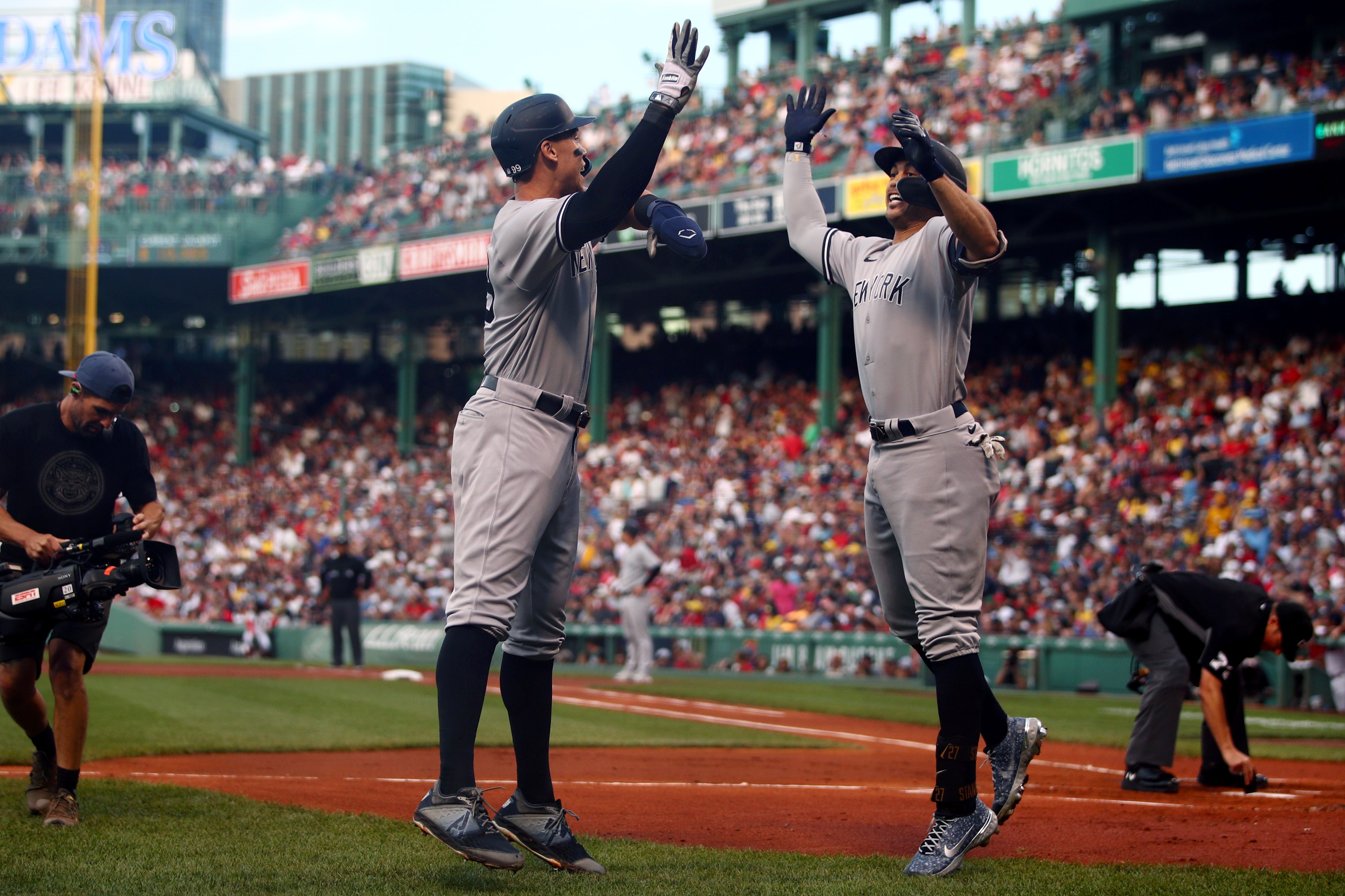BOSTON, MA - JULY 10:  Giancarlo Stanton #27 of the New York Yankees is greeted by teammate Aaron Judge #99 after hitting a two-run home run in the first inning during the game between the New York Yankees and the Boston Red Sox at Fenway Park on Sunday, July 10, 2022 in Boston, Massachusetts. (Photo by Adam Glanzman/MLB Photos via Getty Images)