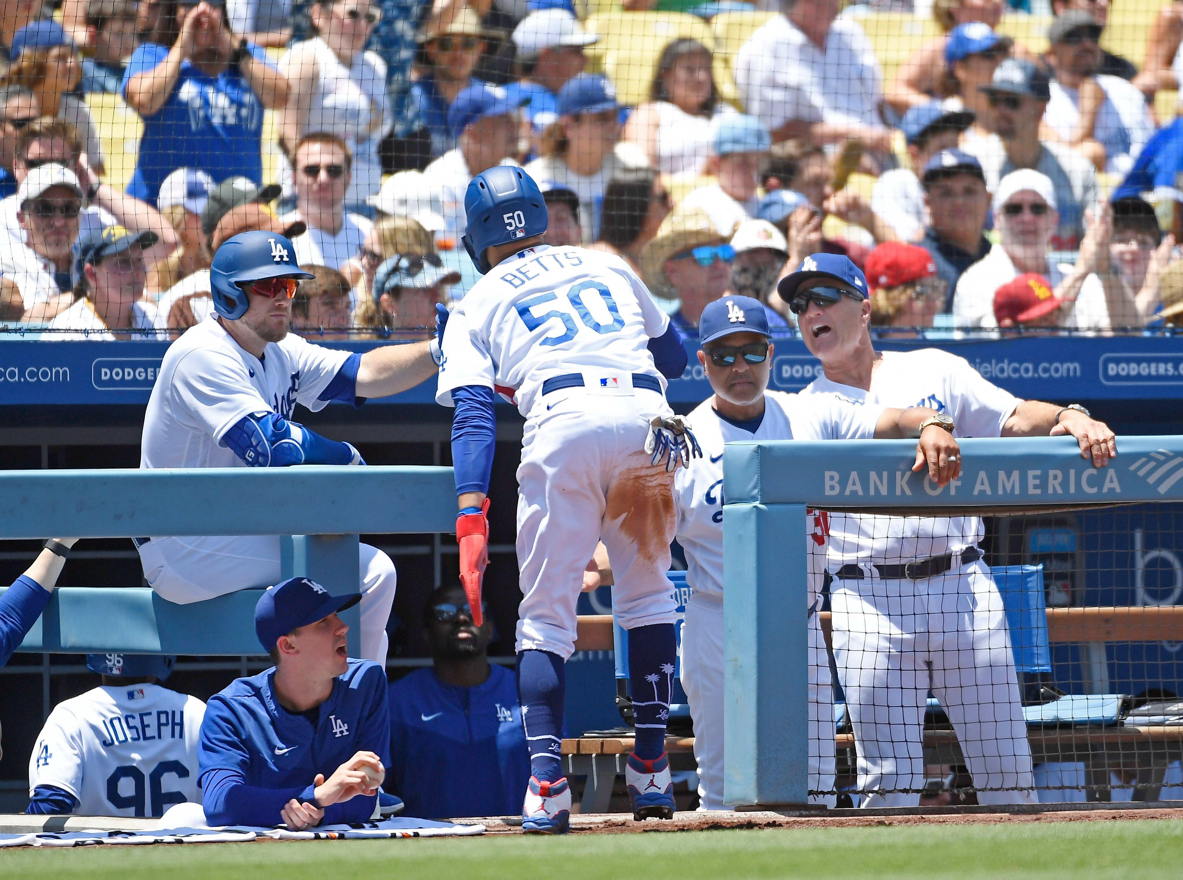 LOS ANGELES, CA - JULY 03: Mookie Betts #50 of the Los Angeles Dodgers is congratulated by manager Dave Roberts #30 after scoring a run on a double by Trea Turner against starting pitcher MacKenzie Gore #1 of the San Diego Padres during the first inning at Dodger Stadium on July 3, 2022 in Los Angeles, California. Betts is coming back from an injury sustained on June 15th. (Photo by Kevork Djansezian/Getty Images)