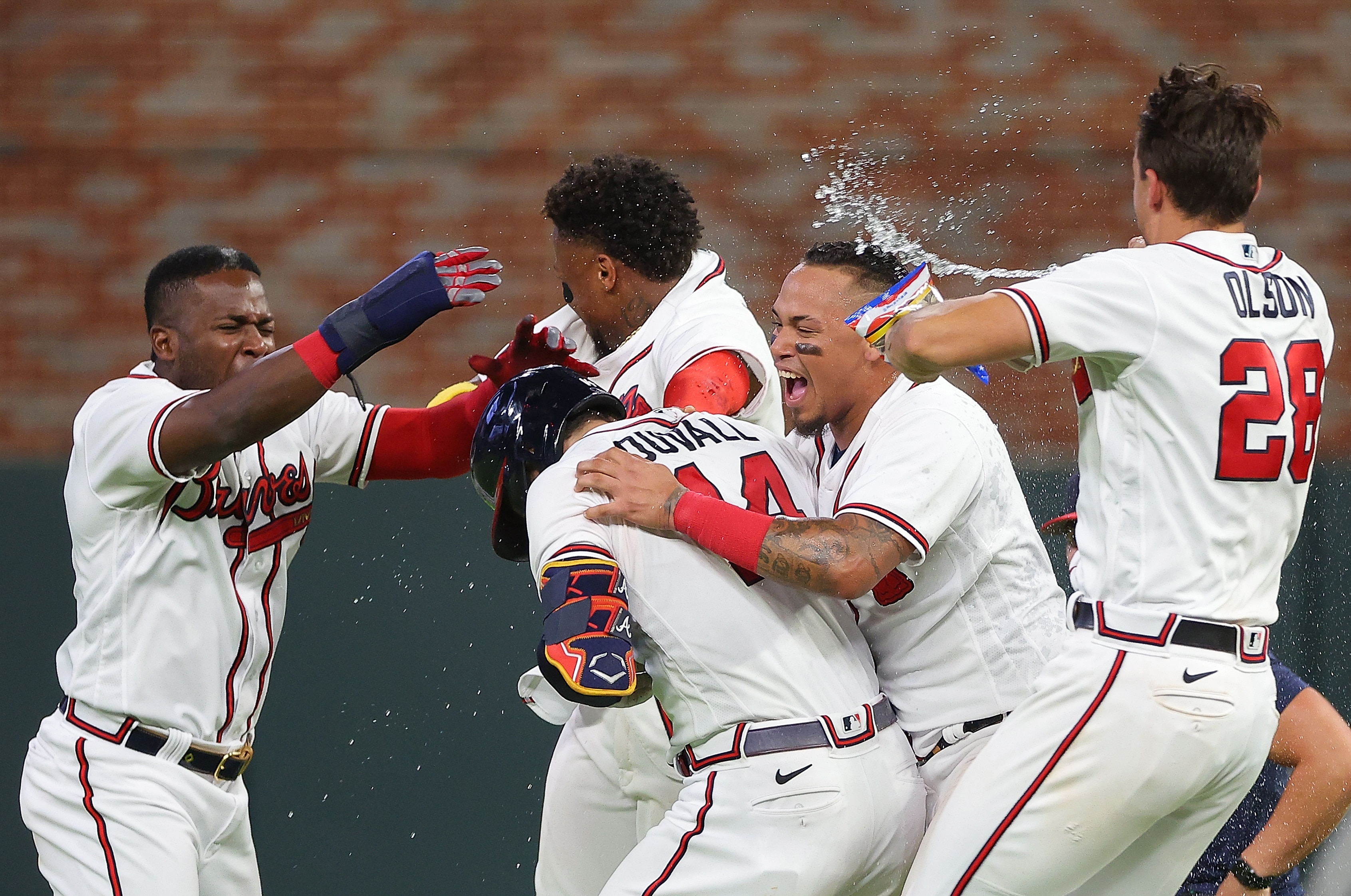 ATLANTA, GEORGIA - JUNE 22:  Adam Duvall #14 of the Atlanta Braves celebrates with Guillermo Heredia #38, Orlando Arcia #11, Ronald Acuna Jr. #13 and Matt Olson #28 after hitting a walk-off single to score the winning run by William Contreras #24 in the ninth inning against the San Francisco Giants at Truist Park on June 22, 2022 in Atlanta, Georgia. (Photo by Kevin C. Cox/Getty Images)