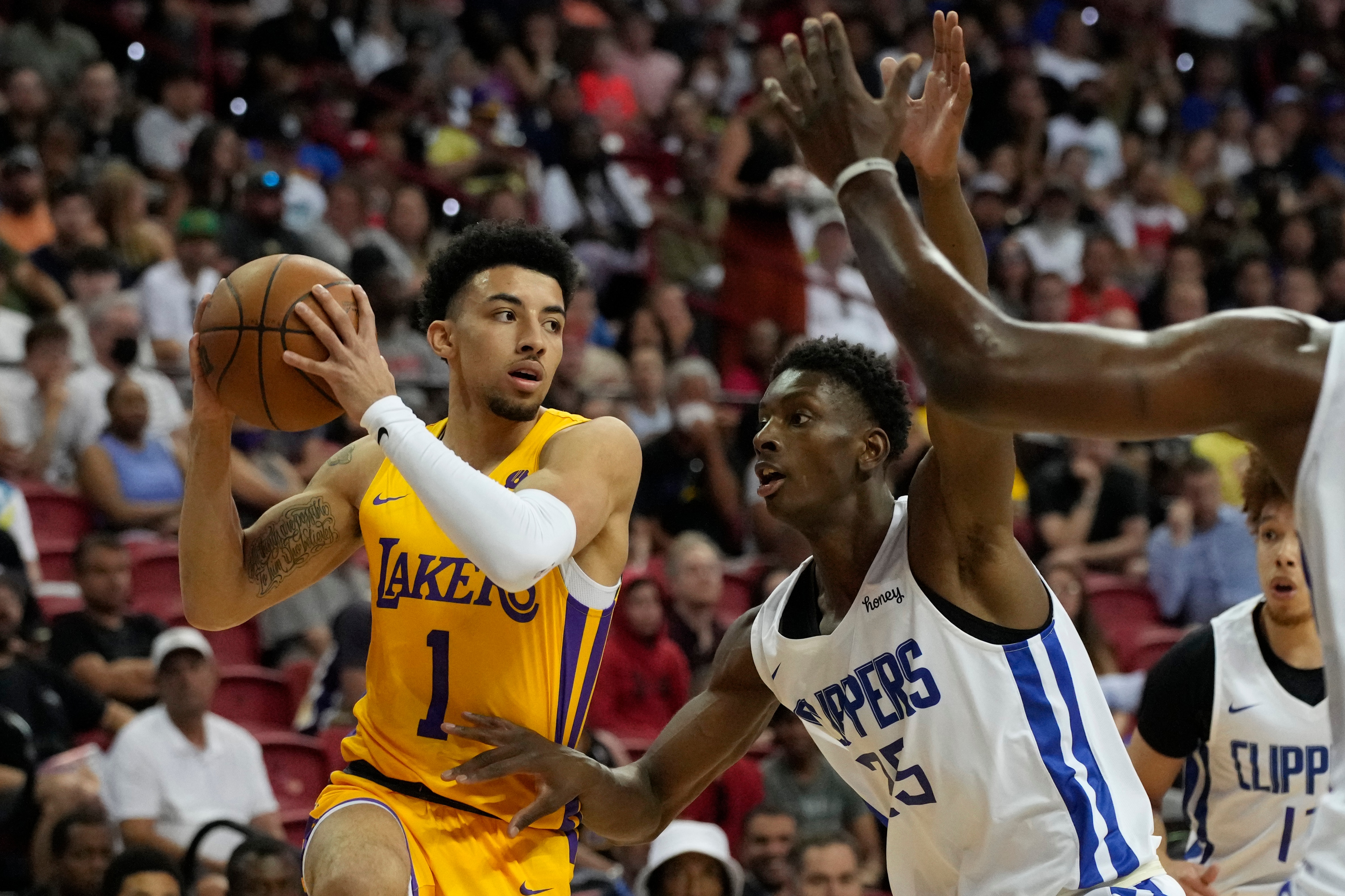 Los Angeles Lakers' Scotty Pippen Jr. passes around Los Angeles Clippers' Moussa Diabate during the first half an NBA summer league basketball game Tuesday, July 12, 2022, in Las Vegas. (AP Photo/John Locher)
