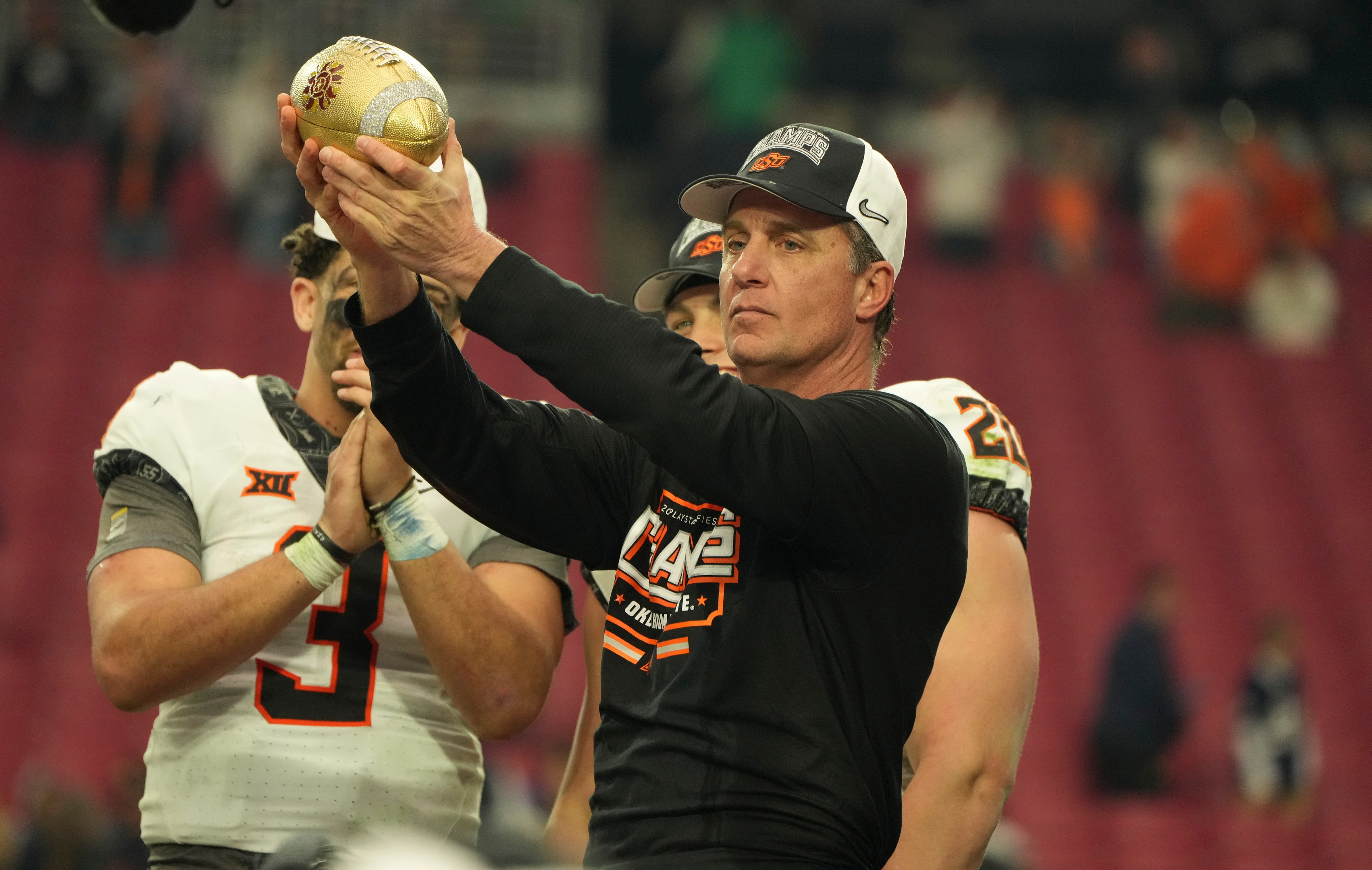 GLENDALE, AZ - JANUARY 01: Oklahoma State Cowboys head coach Mike Gundy accepts the Fiesta Bowl  award for winning the Playstation Fiesta Bowl game between the Notre Dame Fighting Irish vs the Oklahoma State Cowboys on January 1st, 2022 at State Farm Stadium in Glendale, AZ. (Photo by Jeff Halstead/Icon Sportswire via Getty Images)