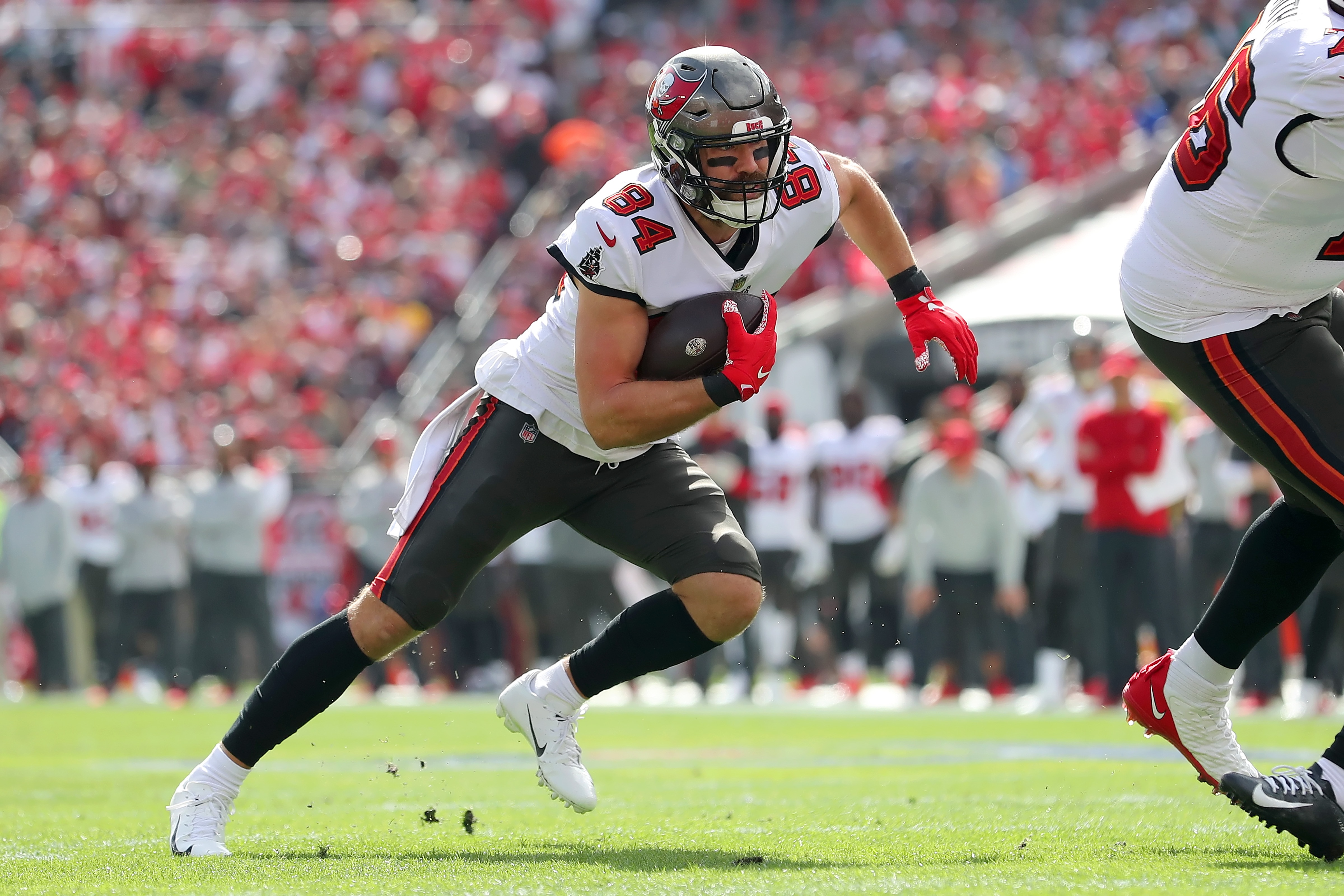 TAMPA, FL - JANUARY 16: Tampa Bay Buccaneers Tight End Cameron Brate (84) runs with the ball after making a catch during the NFL Wild Card game between the Philadelphia Eagles and the Tampa Bay Buccaneers on January 16, 2022 at Raymond James Stadium in Tampa, Florida. (Photo by Cliff Welch/Icon Sportswire via Getty Images)