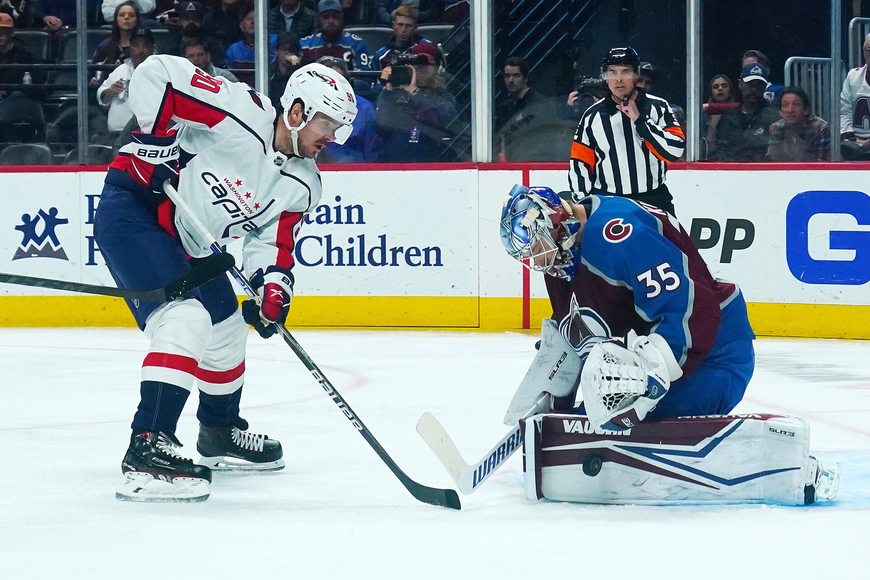 Colorado Avalanche goaltender Darcy Kuemper (35) blocks a shot by Washington Capitals left wing Marcus Johansson (90) during the second period of an NHL hockey game Monday, April 18, 2022, in Denver. (AP Photo/Jack Dempsey)