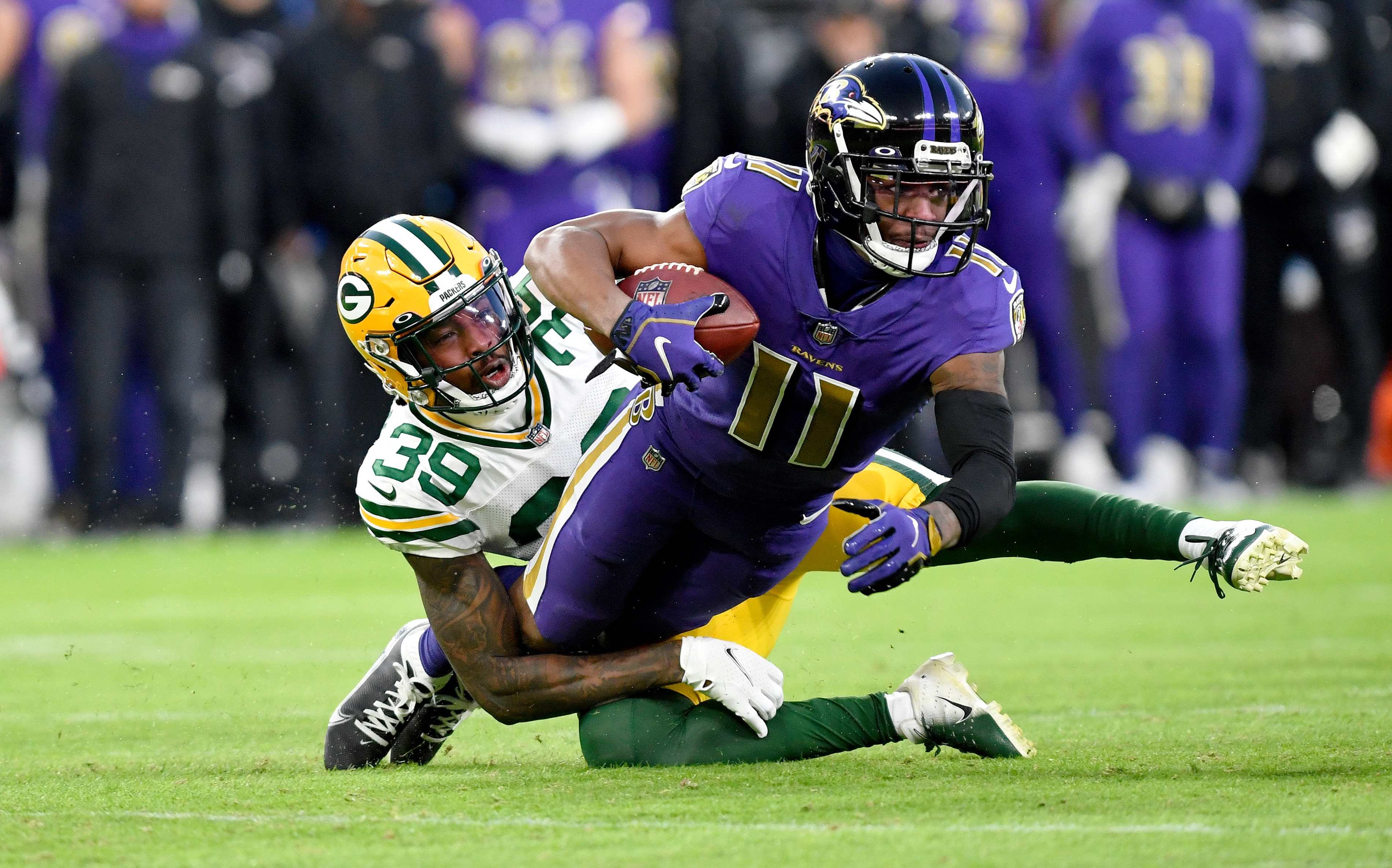 BALTIMORE, MD - DECEMBER 19: Ravens wide receiver James Proche II (11) falls forwards after catching a pass while Packers cornerback Chandon Sullivan (39) tackles him during the Green Bay Packers versus Baltimore Ravens NFL game at M&T Bank Stadium on December 19, 2021 in Baltimore, MD. (Photo by Randy Litzinger/Icon Sportswire via Getty Images)