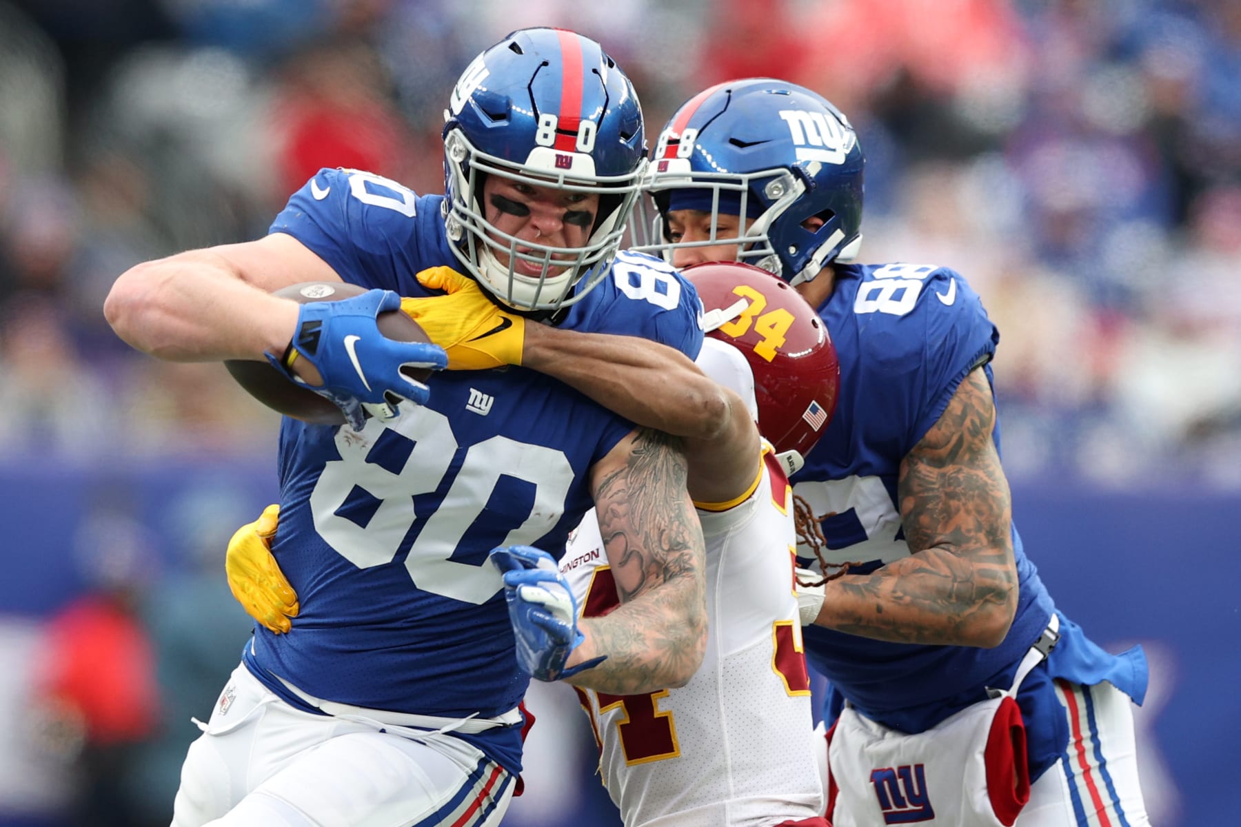 EAST RUTHERFORD, NEW JERSEY - JANUARY 09: Kyle Rudolph #80 of the New York Giants is tackled by Darryl Roberts #34 of the Washington Football Team in the first quarter of the game at MetLife Stadium on January 09, 2022 in East Rutherford, New Jersey. (Photo by Elsa/Getty Images)