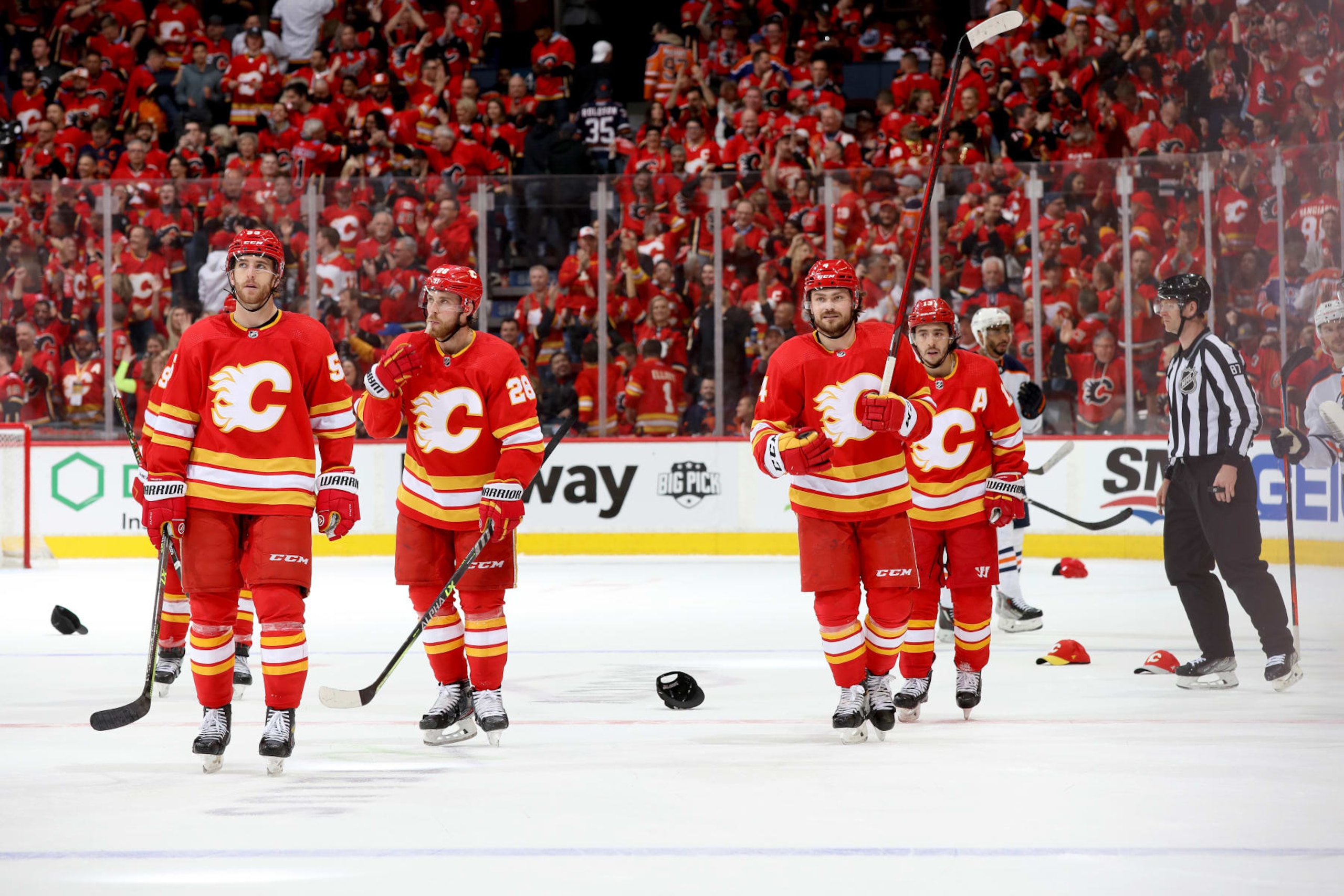 CALGARY, ALBERTA - MAY 18: Johnny Gaudreau #13, Rasmus Andersson #4, and teammates of the Calgary Flames celebrate a goal against the Edmonton Oilers in Game One of the Second Round of the 2022 Stanley Cup Playoffs at Scotiabank Saddledome on May 18, 2022 in Calgary, Alberta. (Photo by Gerry Thomas/NHLI via Getty Images)
