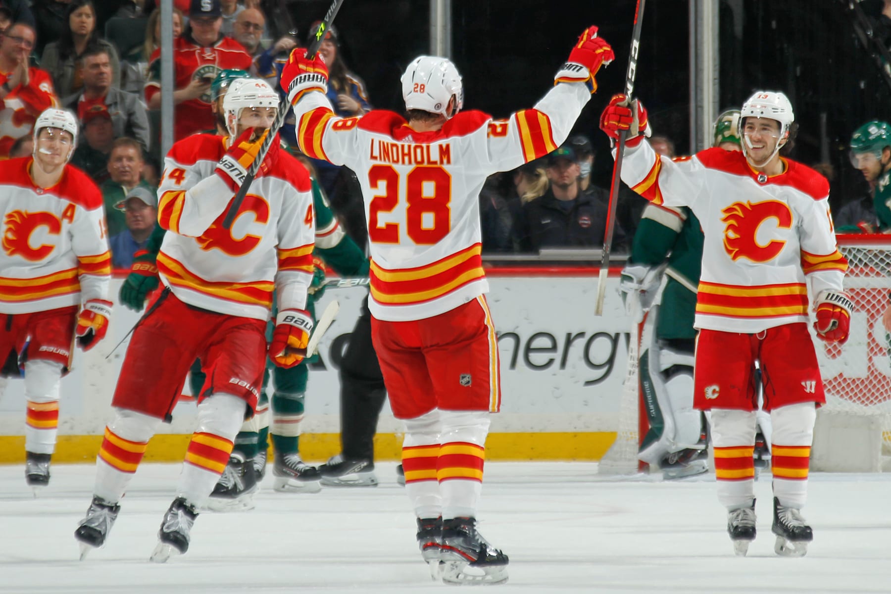 SAINT PAUL, MN - APRIL 28: Elias Lindholm #28 celebrates his goal with his teammates Erik Gudbranson #44 and Johnny Gaudreau #13 of the Calgary Flames against the Minnesota Wild during the game at the Xcel Energy Center on April 28, 2022 in Saint Paul, Minnesota. (Photo by Bruce Kluckhohn/NHLI via Getty Images)