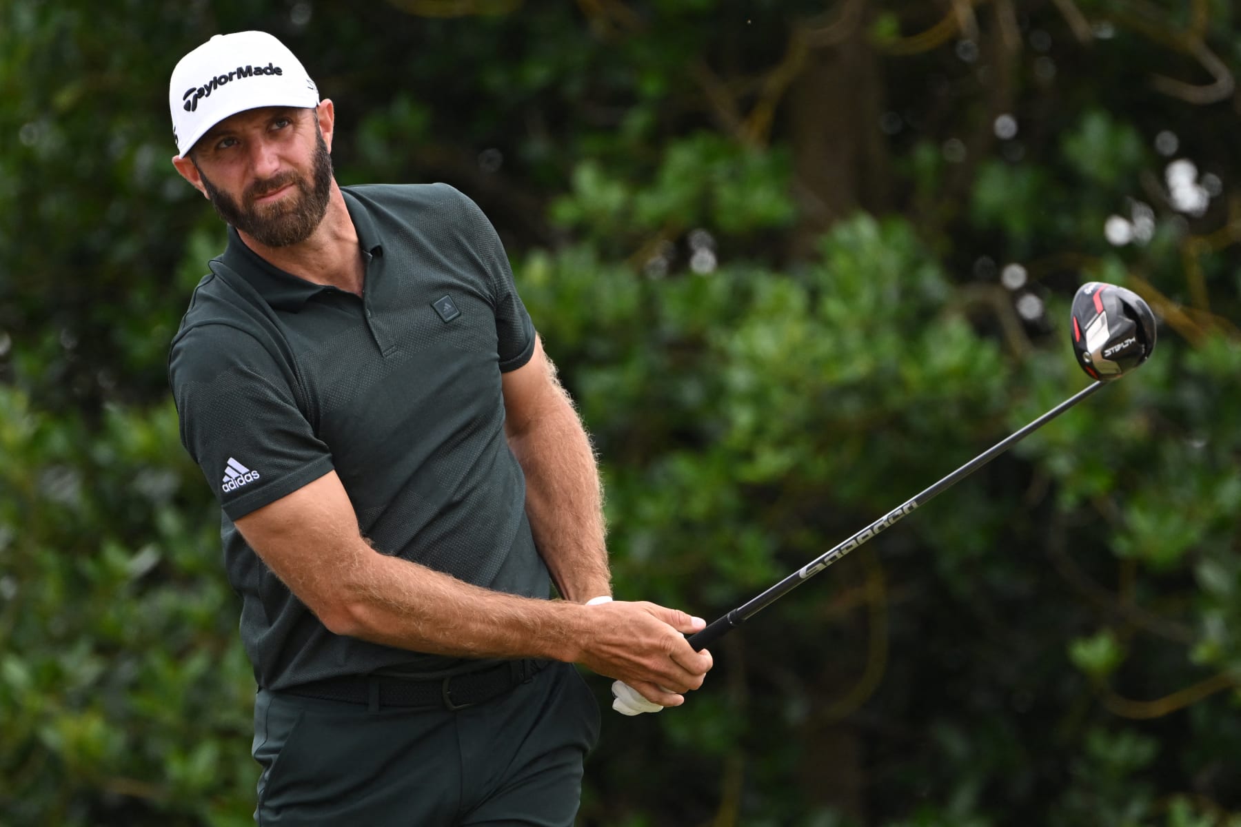 US golfer Dustin Johnson watches his drive from the 3rd tee during his final round on day 4 of The 150th British Open Golf Championship on The Old Course at St Andrews in Scotland on July 17, 2022. - RESTRICTED TO EDITORIAL USE (Photo by Paul ELLIS / AFP) / RESTRICTED TO EDITORIAL USE (Photo by PAUL ELLIS/AFP via Getty Images)
