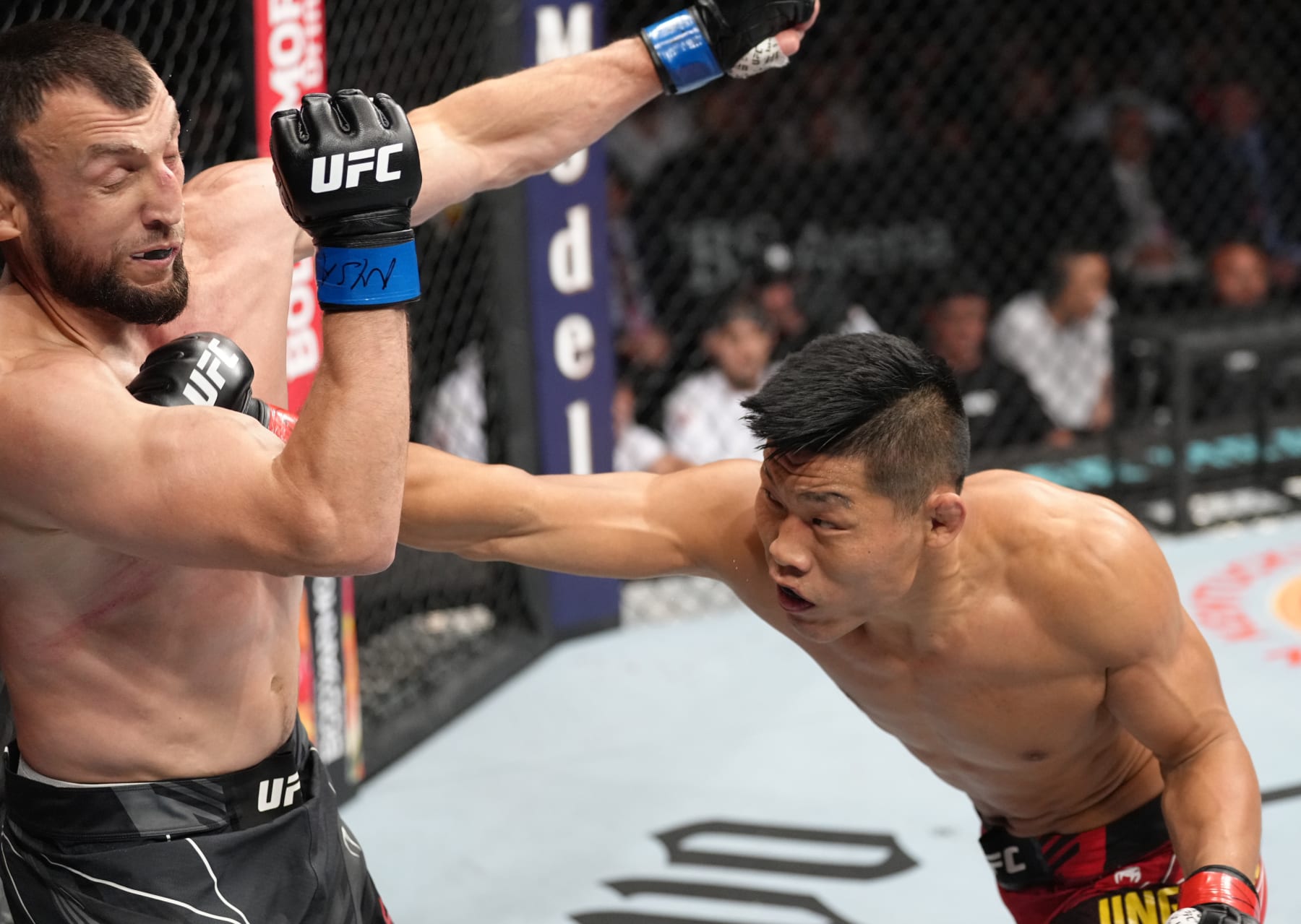 ELMONT, NEW YORK - JULY 16: (R-L) Li Jingliang of China punches Muslim Salikhov of Russia in a welterweight fight during the UFC Fight Night event at UBS Arena on July 16, 2022 in Elmont, New York. (Photo by Jeff Bottari/Zuffa LLC)