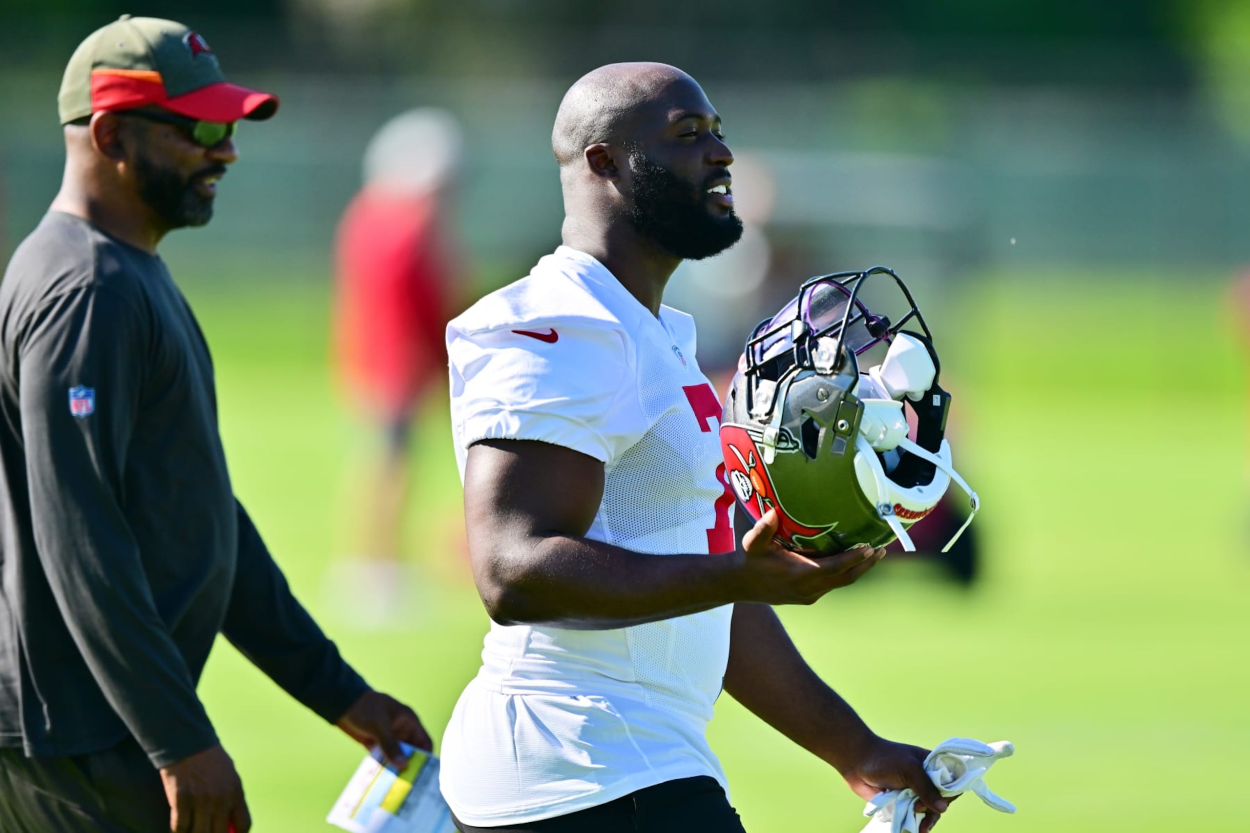TAMPA, FLORIDA - JUNE 08: Leonard Fournette #7 of Tampa Bay Buccaneers walks with running backs coach Todd McNair during the 2022 Buccaneers minicamp at AdventHealth Training Center on June 08, 2022 in Tampa, Florida. (Photo by Julio Aguilar/Getty Images)