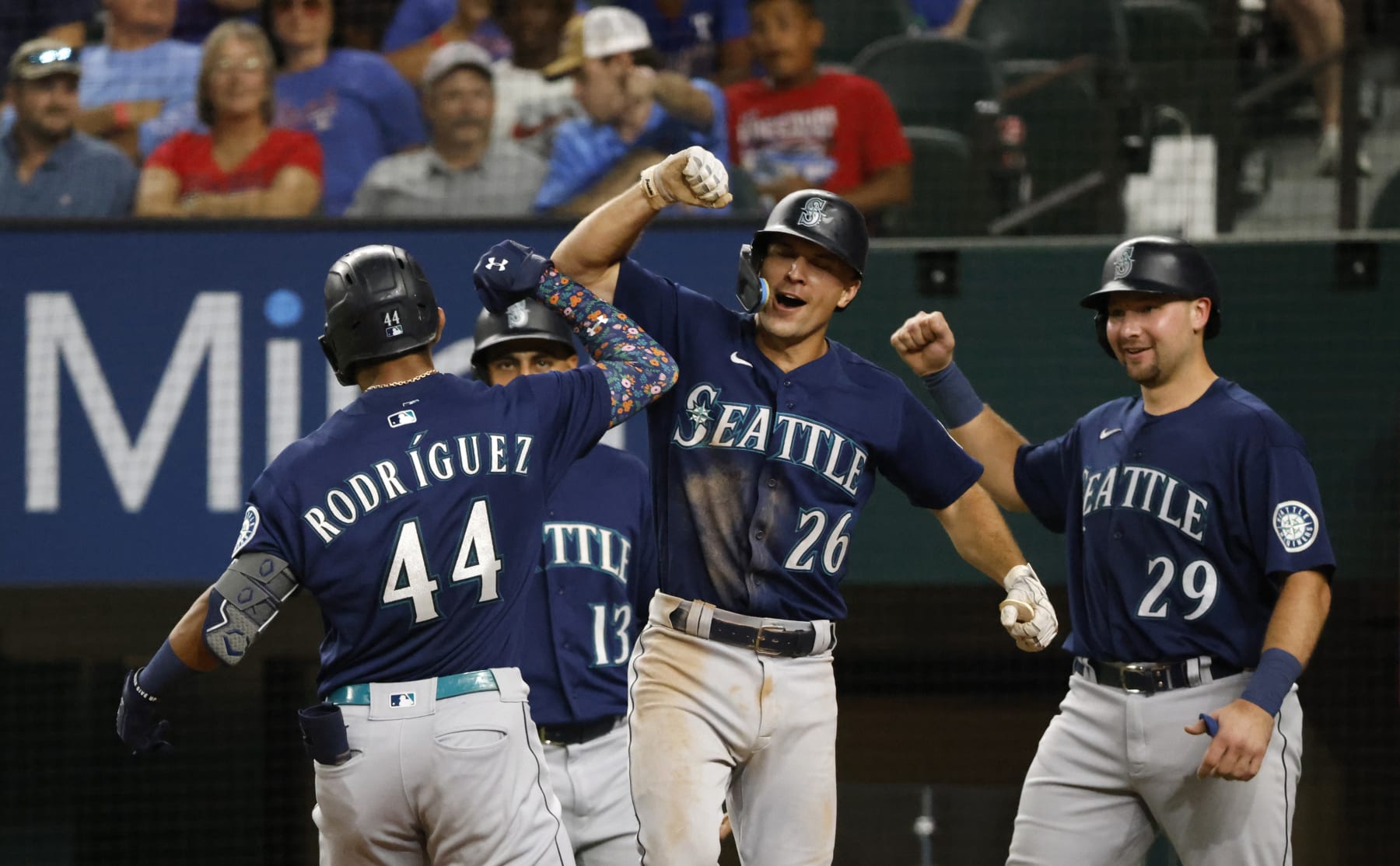 ARLINGTON, TX - JULY 15: Julio Rodriguez #44 of the Seattle Mariners celebrities with teammates Abraham Toro #13, Adam Frazier #26 and Cal Raleigh #29 after hitting a grand slam home run against the Texas Rangers during the eighth inning at Globe Life Field on July 15, 2022 in Arlington, Texas.  (Photo by Ron Jenkins/Getty Images)