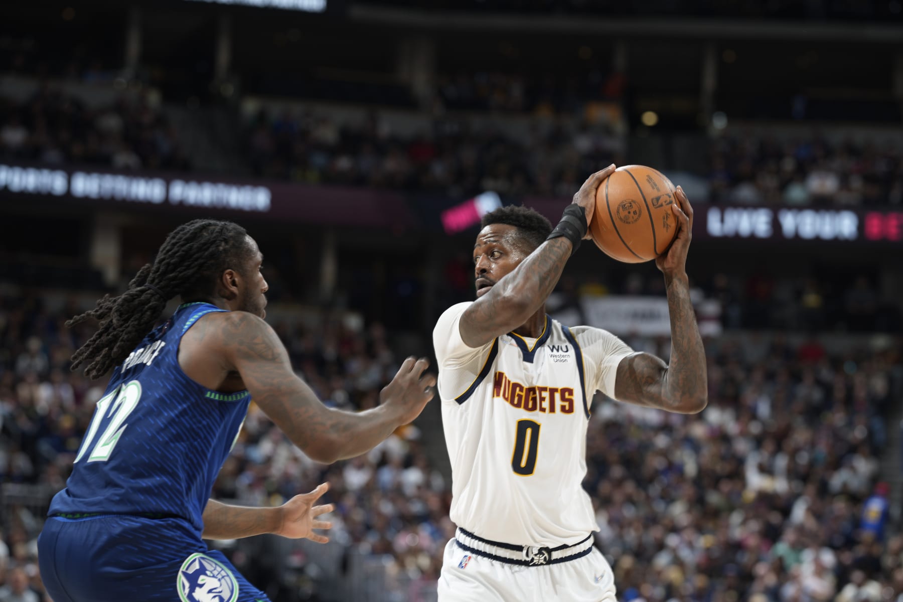 Denver Nuggets forward JaMychal Green (0) looks to pass the ball as Minnesota Timberwolves forward Taurean Prince (12) defends in the second half of an NBA basketball game Friday, April 1, 2022, in Denver. (AP Photo/David Zalubowski)