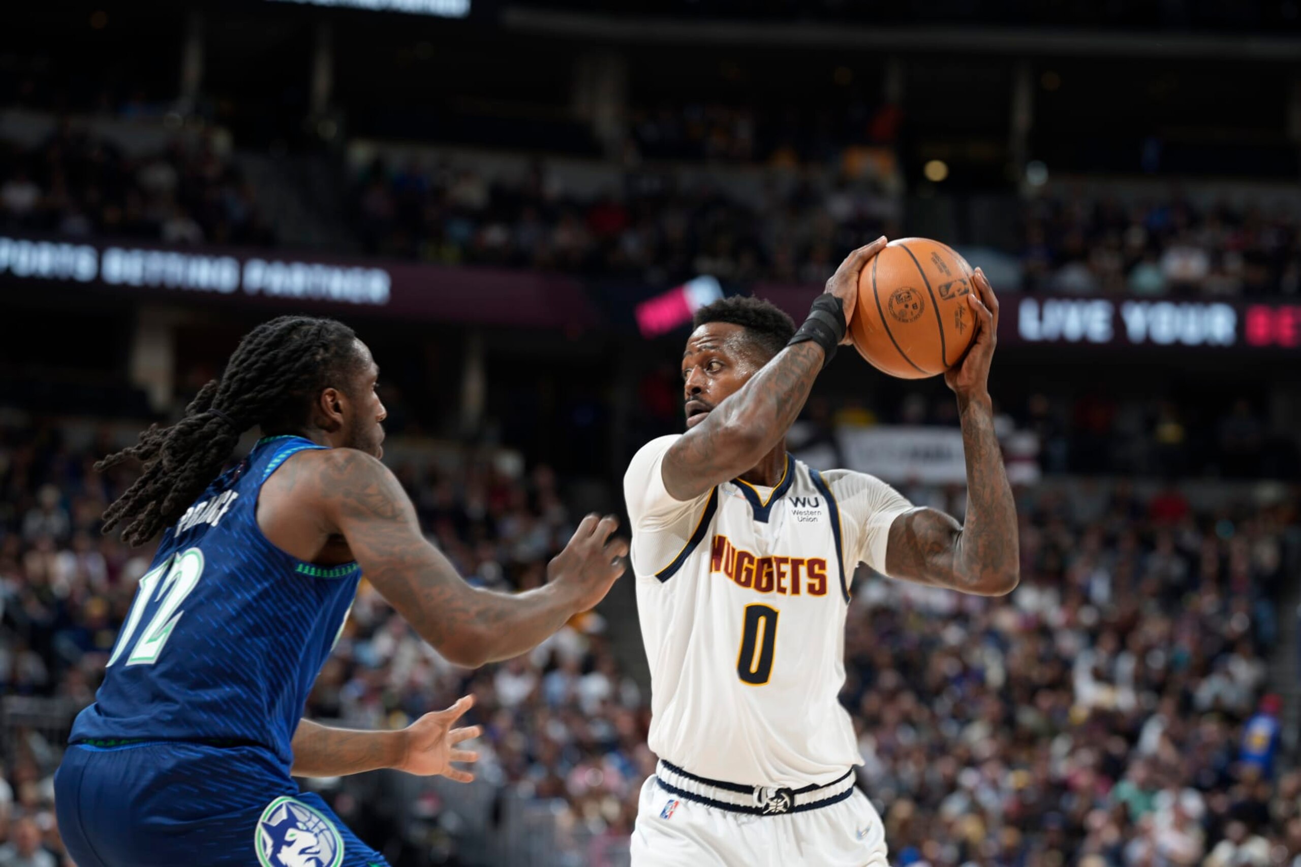Denver Nuggets forward JaMychal Green (0) looks to pass the ball as Minnesota Timberwolves forward Taurean Prince (12) defends in the second half of an NBA basketball game Friday, April 1, 2022, in Denver. (AP Photo/David Zalubowski)