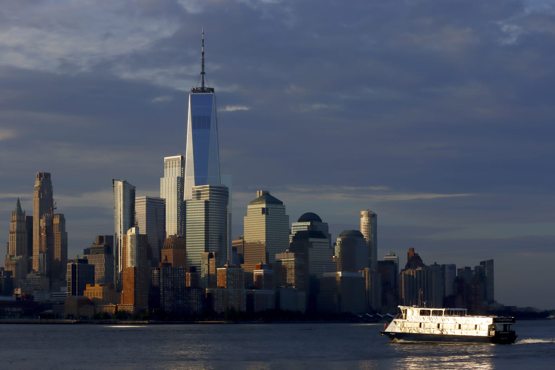 HOBOKEN, NJ - JULY 19: A NY Waterway ferry sails in the Hudson River past the skyline of lower Manhattan and One World Trade Center in New York City at sunrise on July 19, 2022, as seen from Hoboken, New Jersey. (Photo by Gary Hershorn/Getty Images)