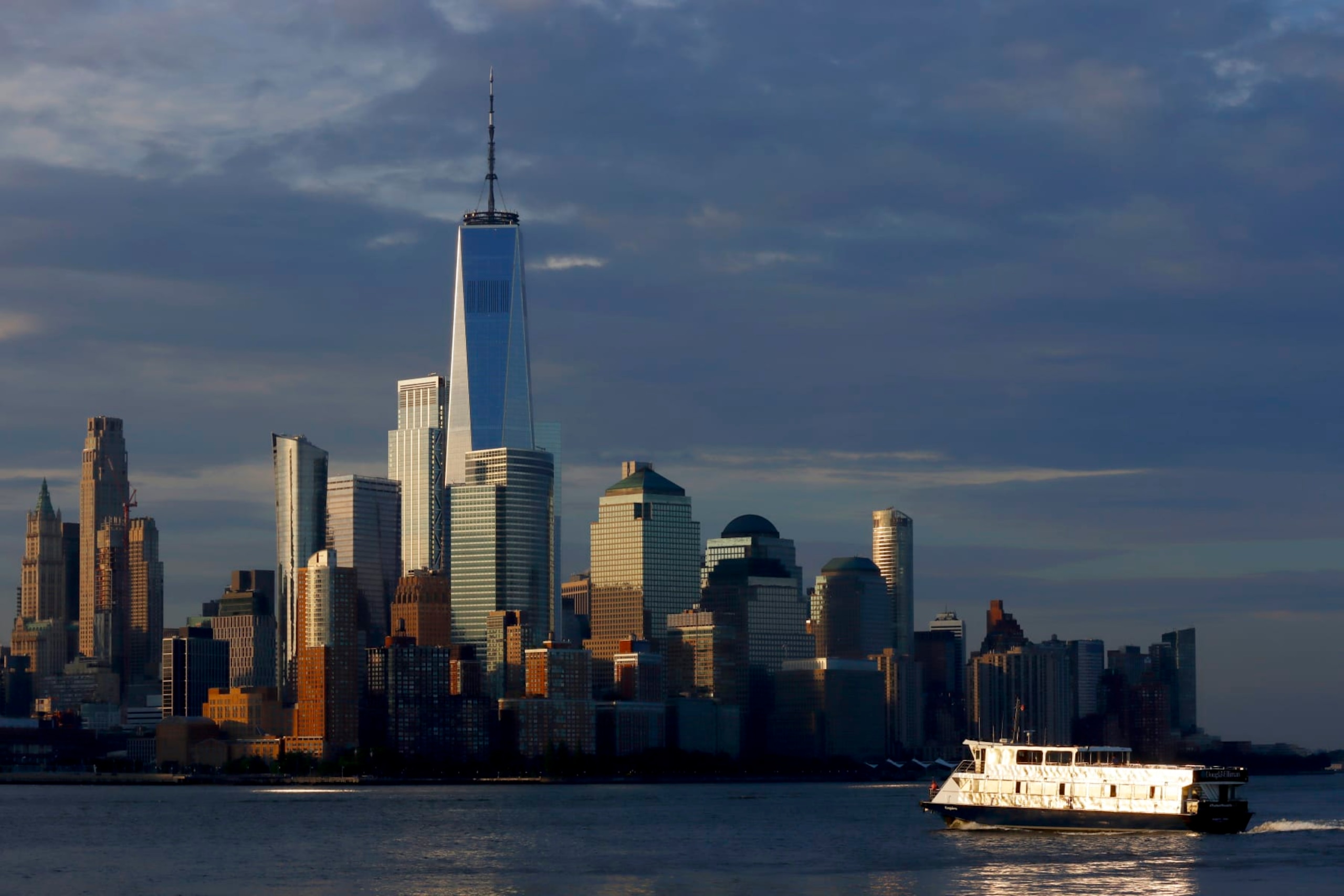HOBOKEN, NJ - JULY 19: A NY Waterway ferry sails in the Hudson River past the skyline of lower Manhattan and One World Trade Center in New York City at sunrise on July 19, 2022, as seen from Hoboken, New Jersey. (Photo by Gary Hershorn/Getty Images)