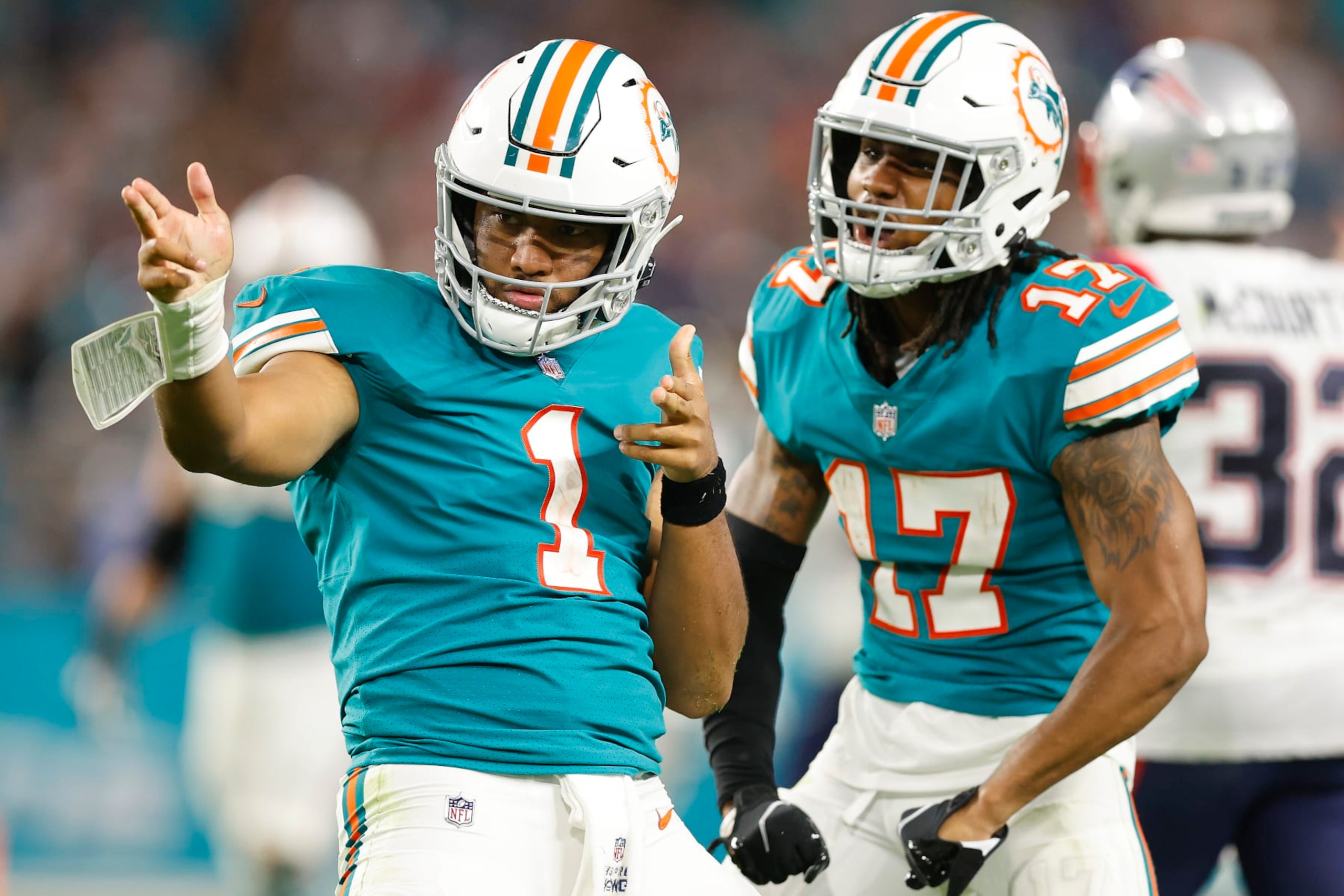 MIAMI GARDENS, FLORIDA - JANUARY 09: Tua Tagovailoa #1 of the Miami Dolphins celebrates a first down with Jaylen Waddle #17 against the New England Patriots during the fourth quarter at Hard Rock Stadium on January 09, 2022 in Miami Gardens, Florida. (Photo by Michael Reaves/Getty Images)