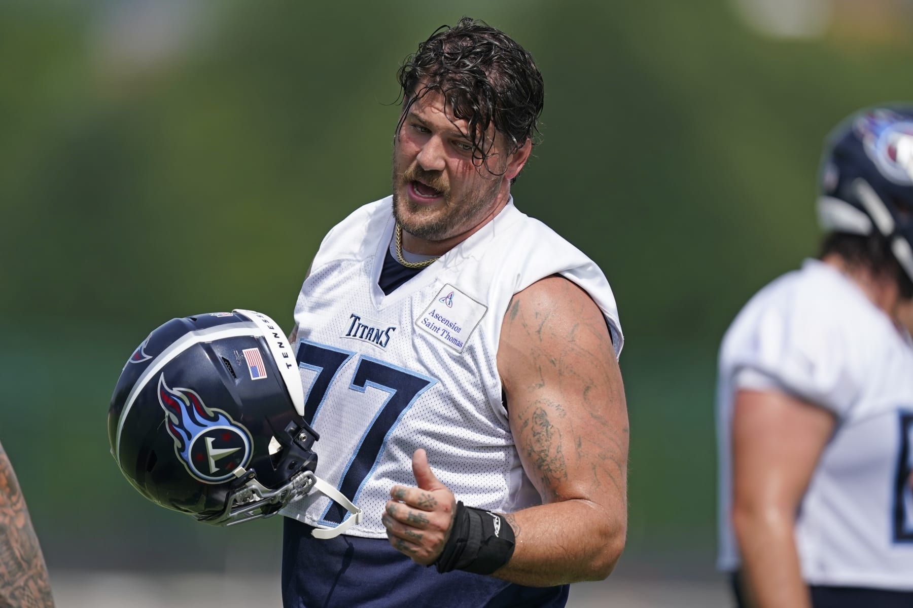 Tennessee Titans tackle Taylor Lewan talks with a teammate at the NFL football team's practice facility Tuesday, June 14, 2022, in Nashville, Tenn. (AP Photo/Mark Humphrey)
