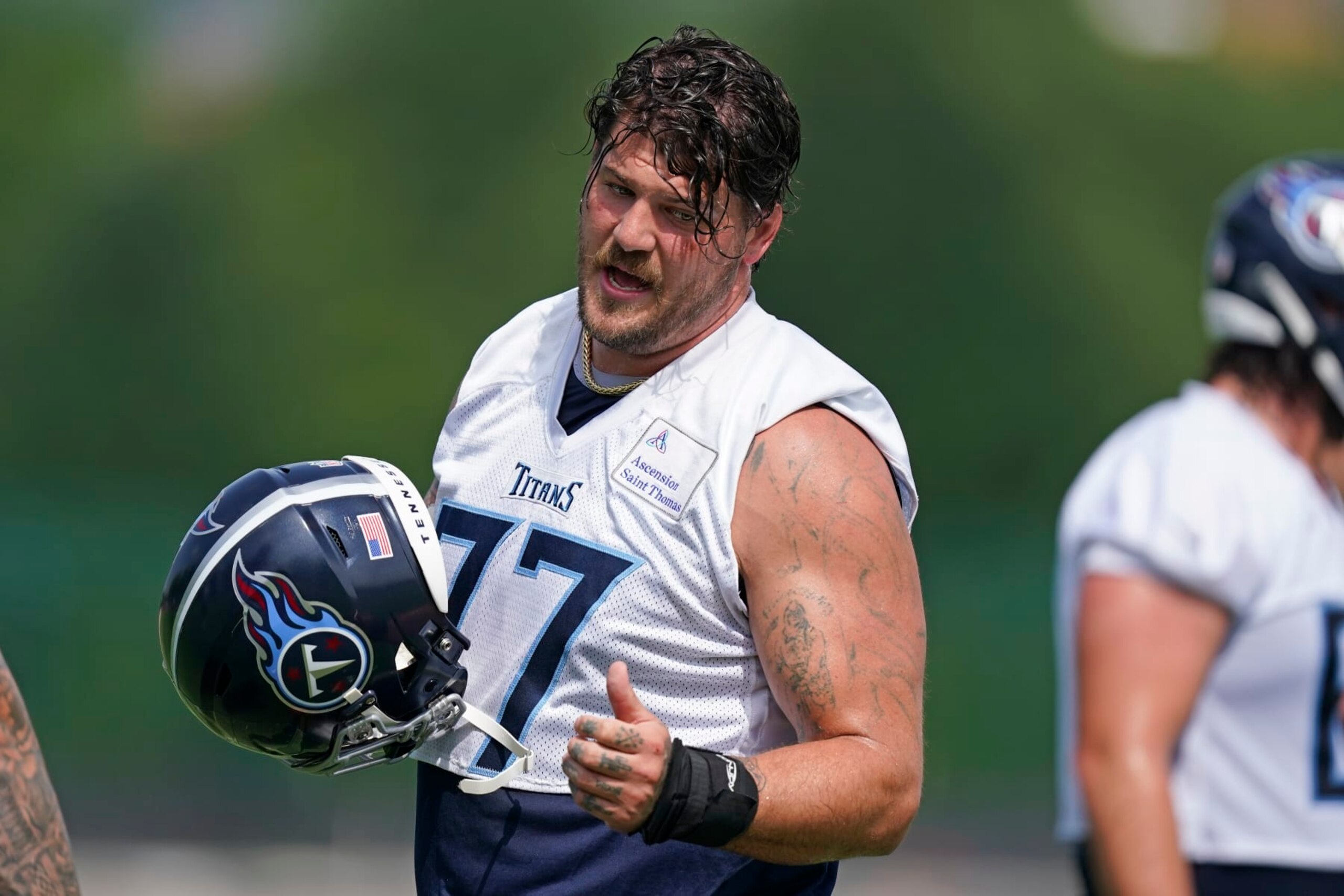 Tennessee Titans tackle Taylor Lewan talks with a teammate at the NFL football team's practice facility Tuesday, June 14, 2022, in Nashville, Tenn. (AP Photo/Mark Humphrey)