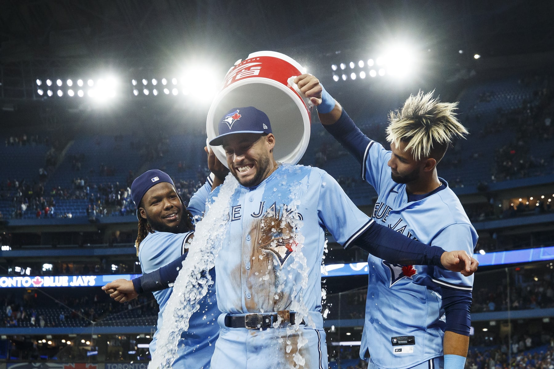 TORONTO, ON - APRIL 30: Vladimir Guerrero Jr. #27 and Lourdes Gurriel Jr. #13 of the Toronto Blue Jays pour ice on George Springer #4 after their 2-1 MLB game against the Houston Astros at Rogers Centre on April 30, 2022 in Toronto, Canada. (Photo by Cole Burston/Getty Images)