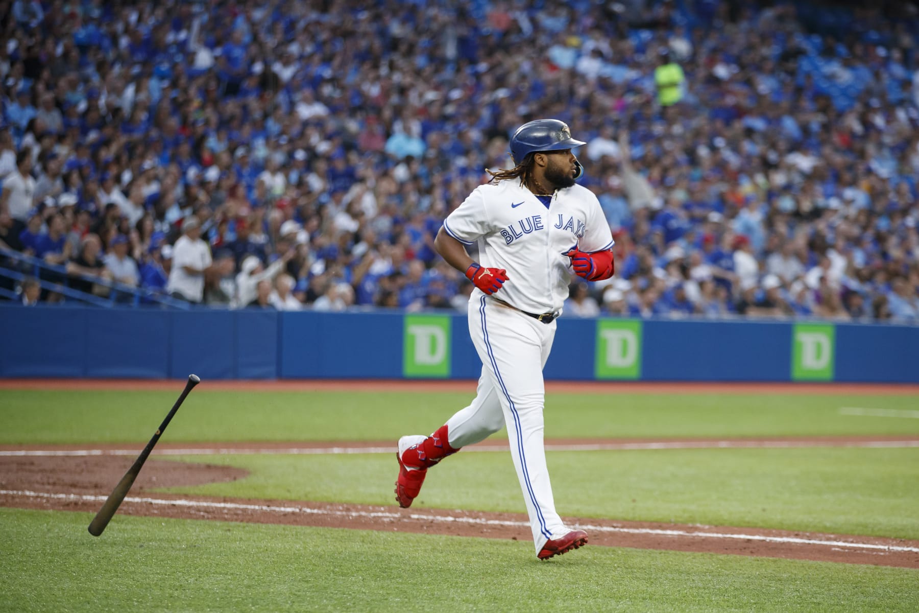 TORONTO, ON - JULY 13: Vladimir Guerrero Jr. #27 of the Toronto Blue Jays hits a sacrifice fly to allow George Springer #4 to score in the fifth inning of their MLB game against the Philadelphia Phillies at Rogers Centre on July 13, 2022 in Toronto, Canada. (Photo by Cole Burston/Getty Images)