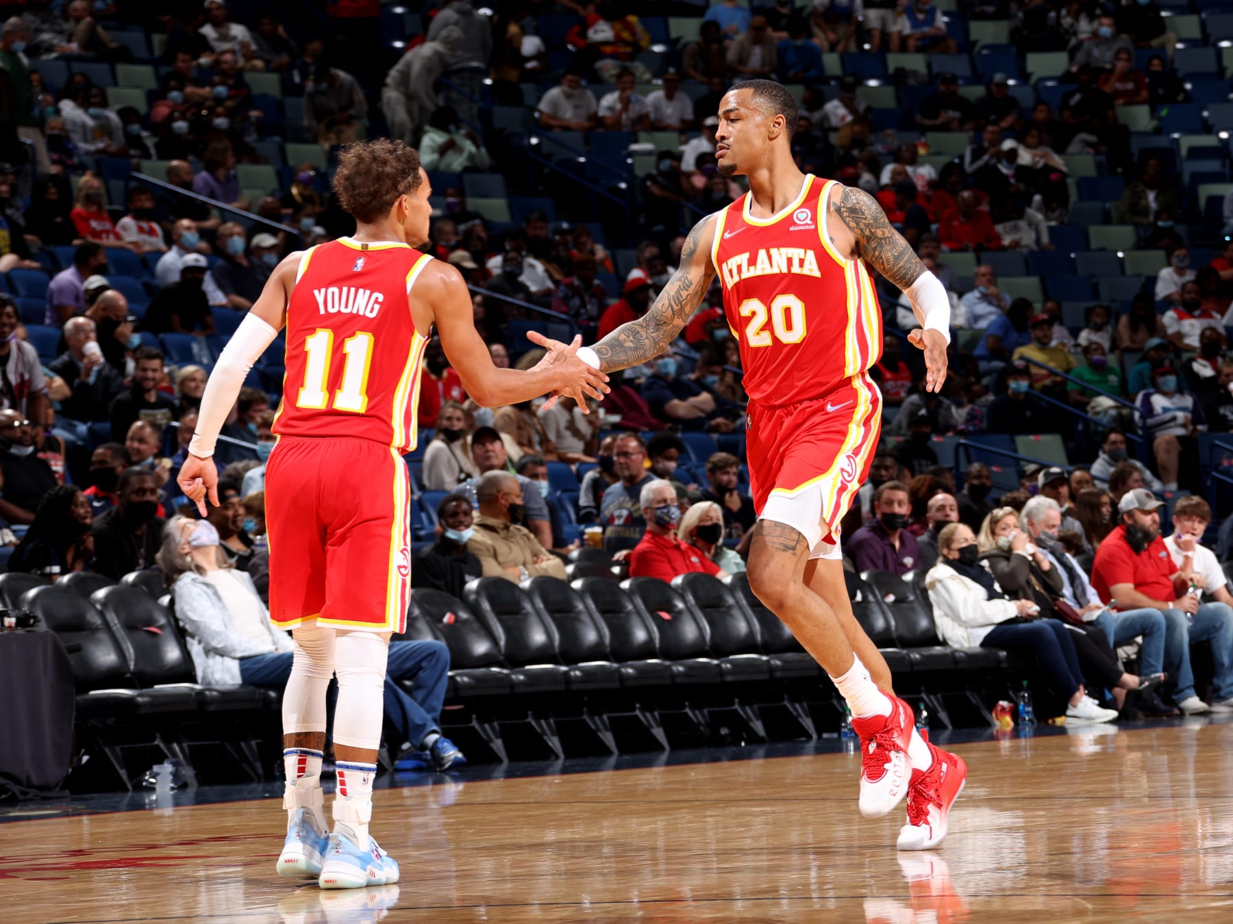 NEW ORLEANS, LA -OCTOBER 27: John Collins #20 of the Atlanta Hawks high fives Trae Young #11 during the game against the New Orleans Pelicans on October 27, 2021 at the Smoothie King Center in New Orleans, Louisiana. NOTE TO USER: User expressly acknowledges and agrees that, by downloading and or using this Photograph, user is consenting to the terms and conditions of the Getty Images License Agreement. Mandatory Copyright Notice: Copyright 2021 NBAE (Photo by Ned Dishman/NBAE via Getty Images)