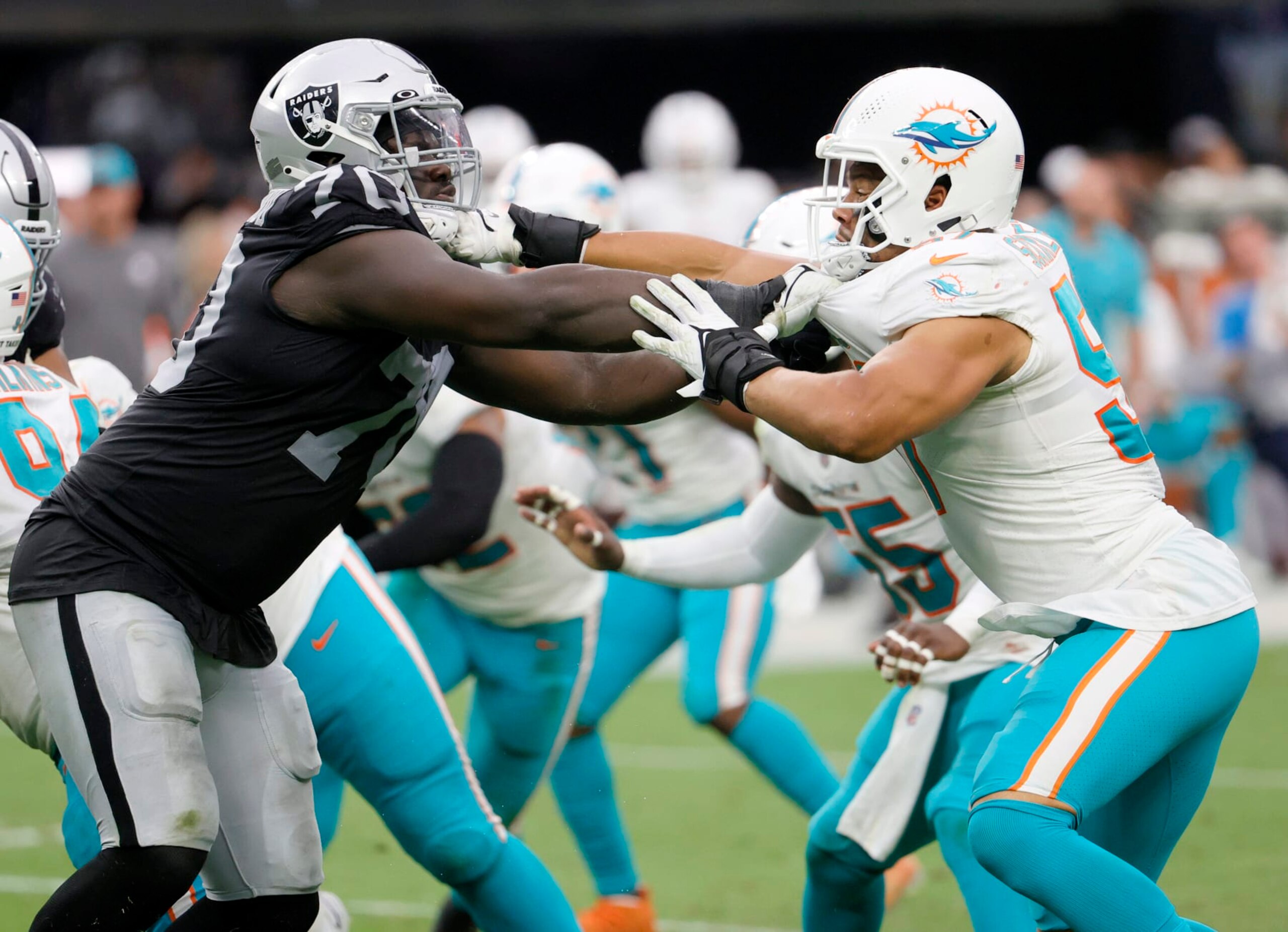 LAS VEGAS, NEVADA - SEPTEMBER 26:  Offensive tackle Alex Leatherwood #70 of the Las Vegas Raiders blocks outside linebacker Brennan Scarlett #57 of the Miami Dolphins during their game at Allegiant Stadium on September 26, 2021 in Las Vegas, Nevada. The Raiders defeated the Dolphins 31-28 in overtime.  (Photo by Ethan Miller/Getty Images)