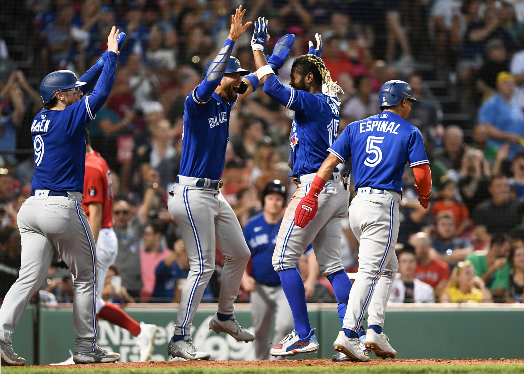 BOSTON, MASSACHUSETTS - JULY 22: Raimel Tapia #15 of the Toronto Blue Jays celebrates with Lourdes Gurriel Jr. #13 and Danny Jansen #9 after hitting an inside the park grand slam against the Boston Red Sox during the third inning at Fenway Park on July 22, 2022 in Boston, Massachusetts. (Photo by Brian Fluharty/Getty Images)
