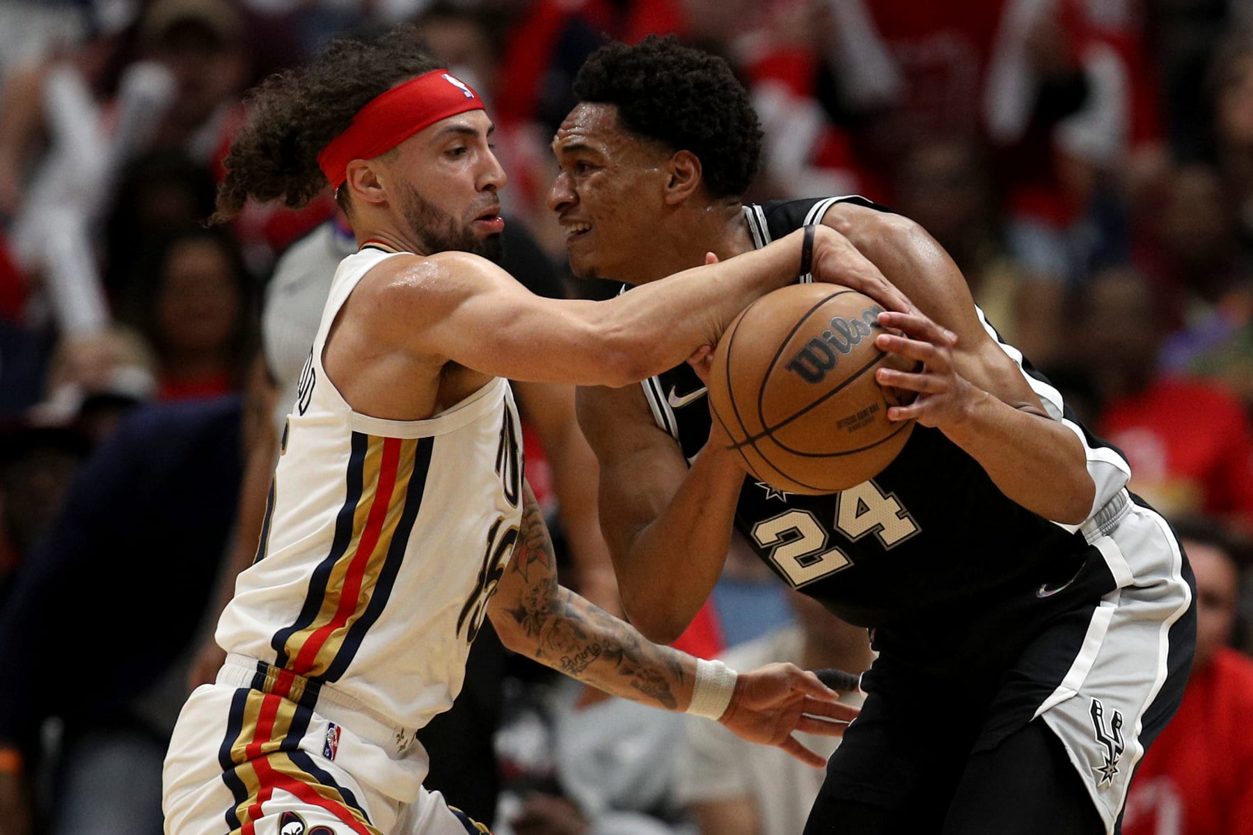NEW ORLEANS, LOUISIANA - APRIL 13: Jose Alvarado #15 of the New Orleans Pelicans steals the ball from Devin Vassell #24 of the San Antonio Spurs during the second quarter of the 2022 NBA Play-In Tournament at Smoothie King Center on April 13, 2022 in New Orleans, Louisiana. NOTE TO USER: User expressly acknowledges and agrees that, by downloading and or using this photograph, User is consenting to the terms and conditions of the Getty Images License Agreement. (Photo by Sean Gardner/Getty Images)