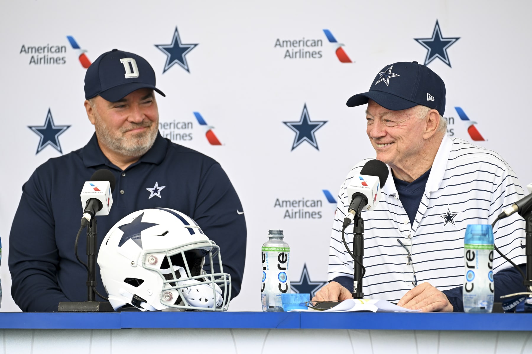 Dallas Cowboys head coach Mike McCarthy, left and owner Jerry Jones, right, react as they take questions from the media at the start of NFL football training camp, Tuesday, July 26, 2022, in Oxnard, Calif. (AP Photo/Gus Ruelas)
