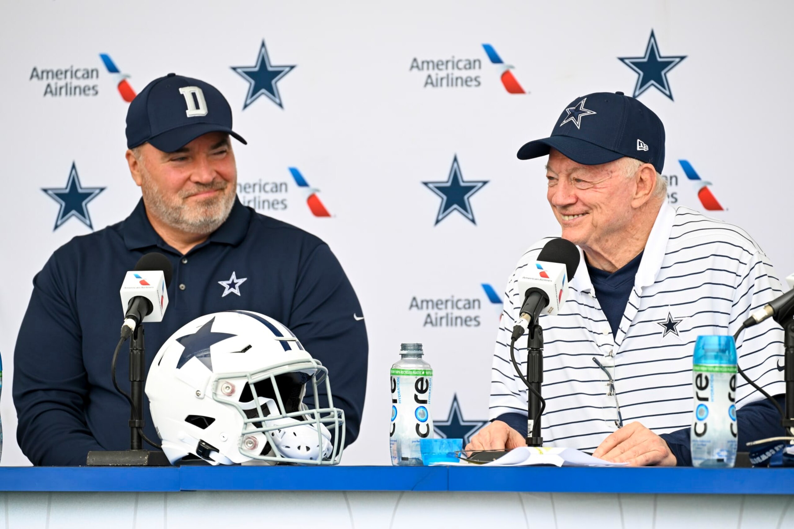 Dallas Cowboys head coach Mike McCarthy, left and owner Jerry Jones, right, react as they take questions from the media at the start of NFL football training camp, Tuesday, July 26, 2022, in Oxnard, Calif. (AP Photo/Gus Ruelas)