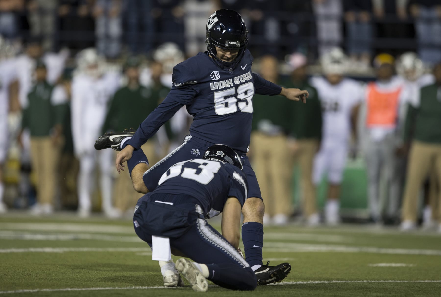 LOGAN, UT -  OCTOBER 22: Connor Coles #59 of the Utah State Aggies kicks one of his four field goals from a hold by Stephen Kotsanlee #63 against the Colorado State Rams during their game at Maverick Stadium October 22, 2021 at  in Logan, Utah.(Photo by Chris Gardner/Getty Images)