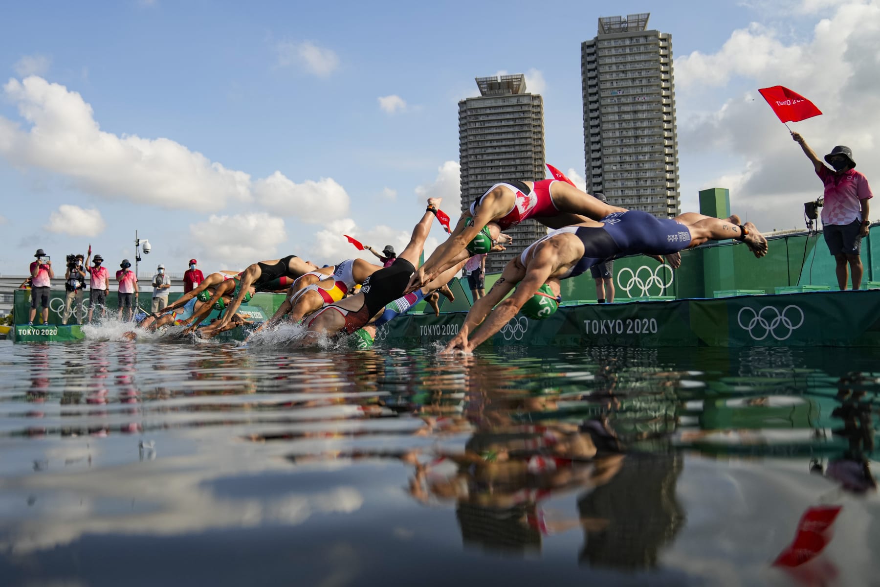 Athletes dive on the start of the first leg of swimming during the mixed relay triathlon at the 2020 Summer Olympics, Saturday, July 31, 2021, in Tokyo, Japan. (AP Photo/Francisco Seco)
