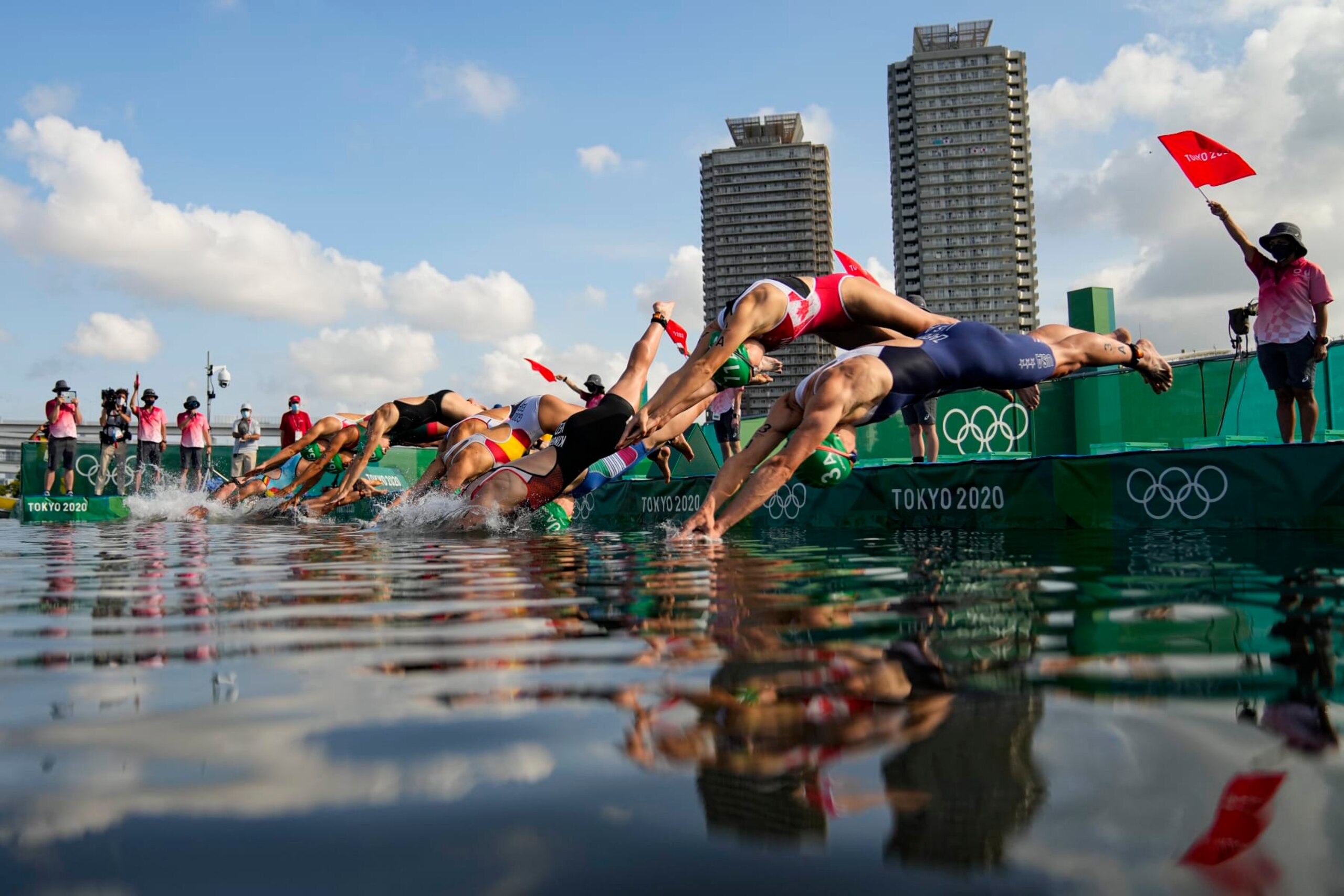 Athletes dive on the start of the first leg of swimming during the mixed relay triathlon at the 2020 Summer Olympics, Saturday, July 31, 2021, in Tokyo, Japan. (AP Photo/Francisco Seco) Athletes dive on the start of the first leg of swimming during the mixed relay triathlon at the 2020 Summer Olympics, Saturday, July 31, 2021, in Tokyo, Japan. (AP Photo/Francisco Seco)