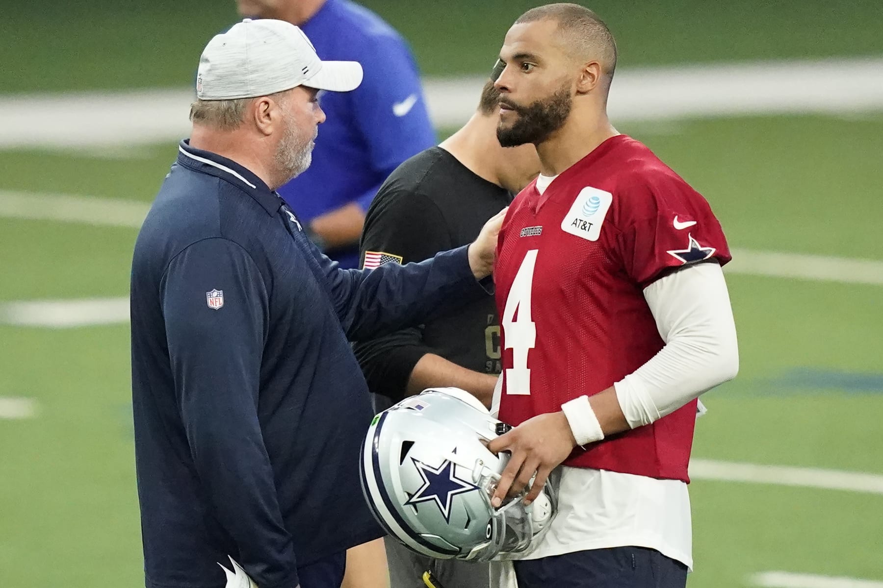 Dallas Cowboys head coach Mike McCarthy, left, speaks to quarterback Dak Prescott (4) during an NFL football team practice in Frisco, Texas, Thursday, June 2, 2022. (AP Photo/LM Otero)