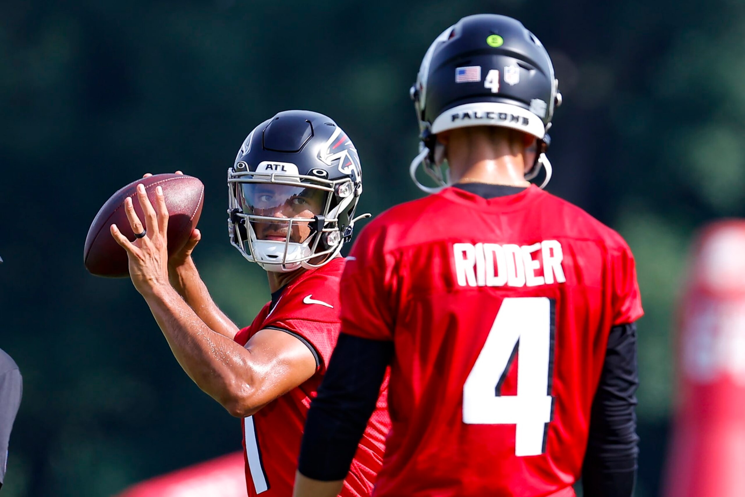 FLOWERY BRANCH, GA - JULY 27: Marcus Mariota #1 of Atlanta Falcons runs through a drill with Desmond Ridder #4 during a training camp practice on July 27, 2022 in Flowery Branch, Georgia. (Photo by Todd Kirkland/Getty Images)