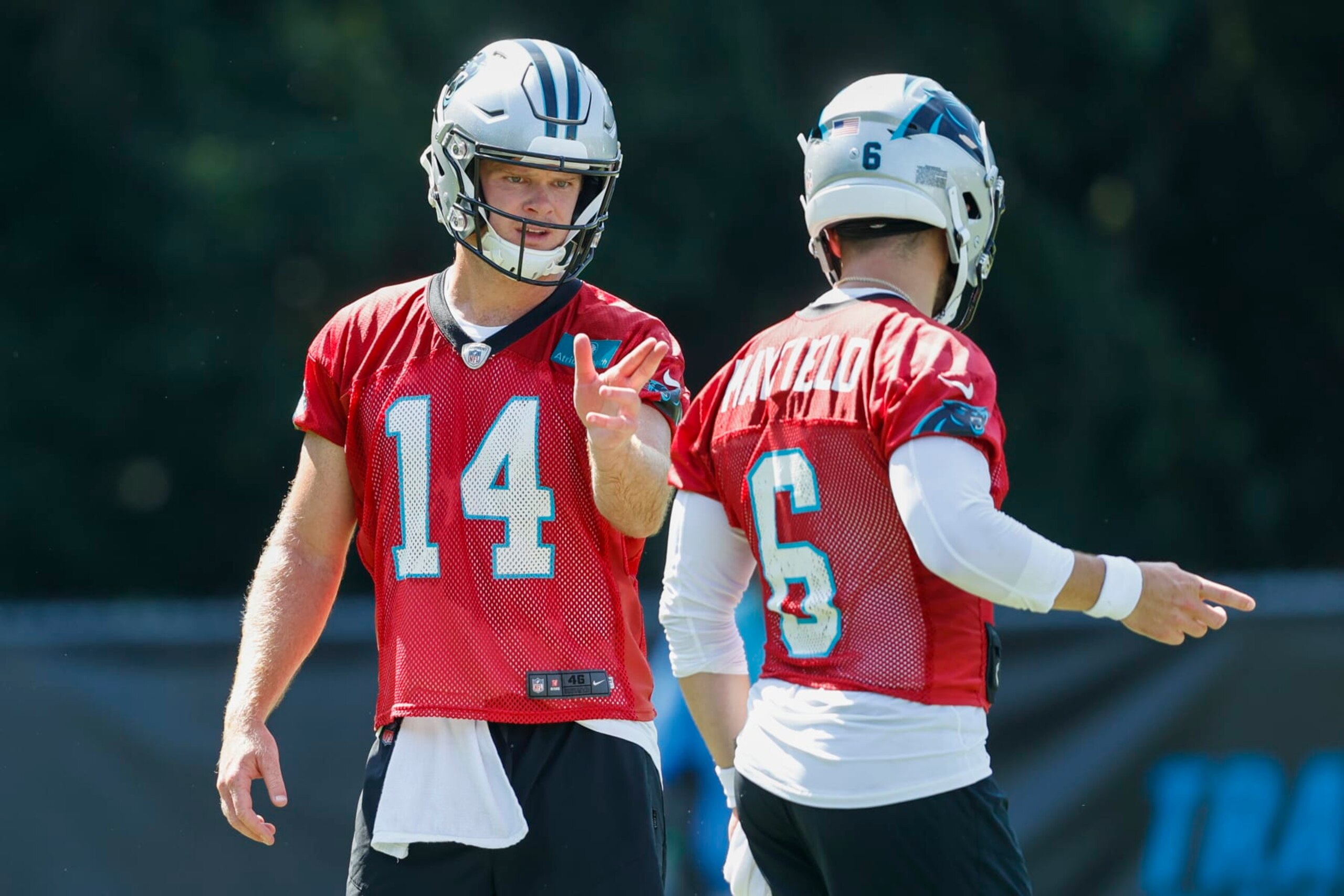 Carolina Panthers quarterback Sam Darnold (14) talks with quarterback Baker Mayfield (6) during drills at the NFL football team's training camp at Wofford College in Spartanburg, S.C., Thursday, July 28, 2022. (AP Photo/Nell Redmond)